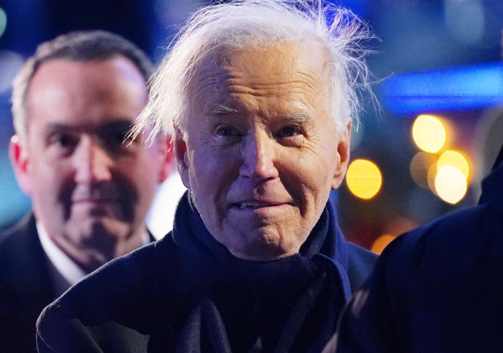 United States President Joe Biden leaving the 102nd National Christmas Tree Lighting Ceremony at The White House, with a 35-foot Red Spruce in the background.