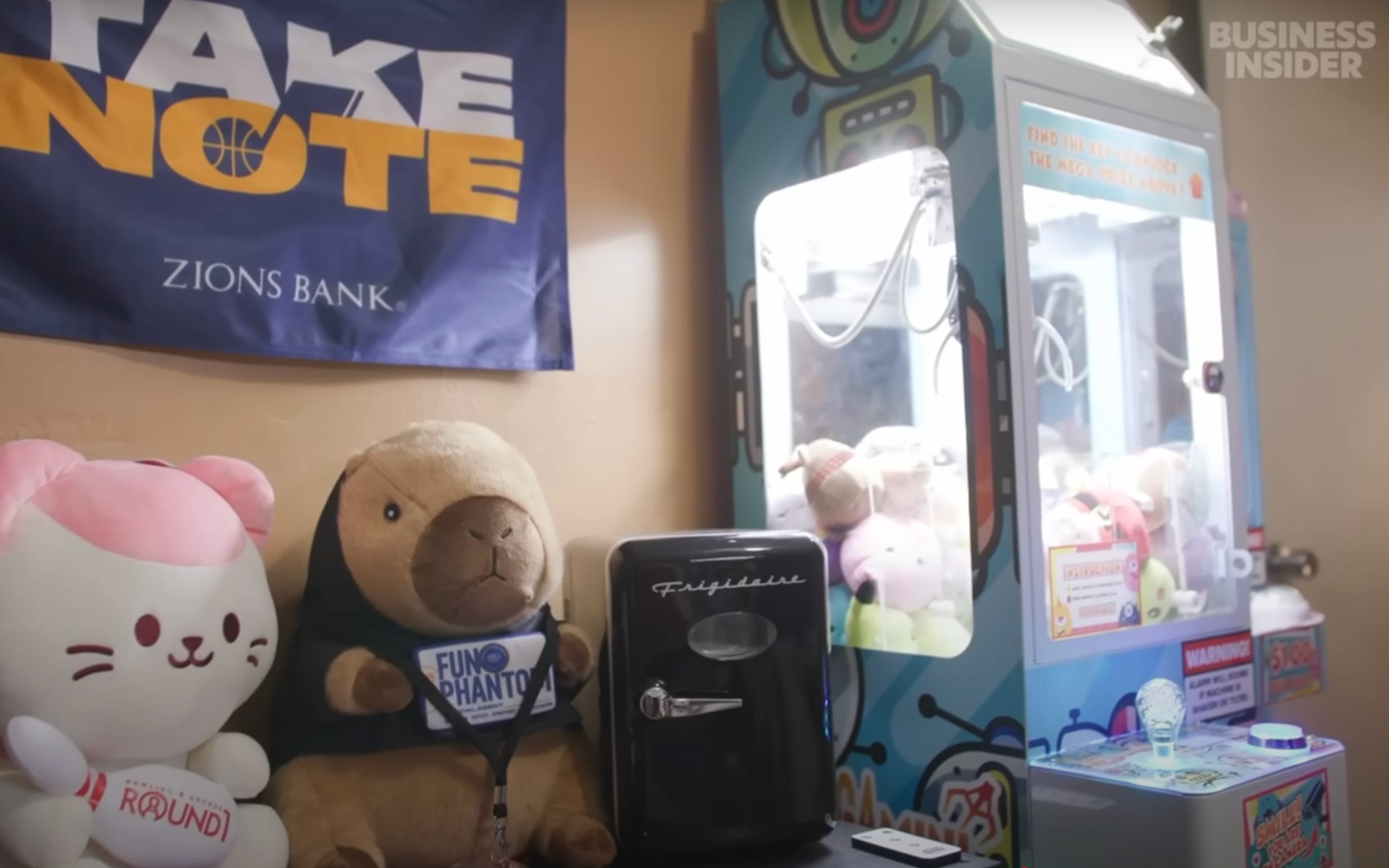 Claw machine with plushies around it
