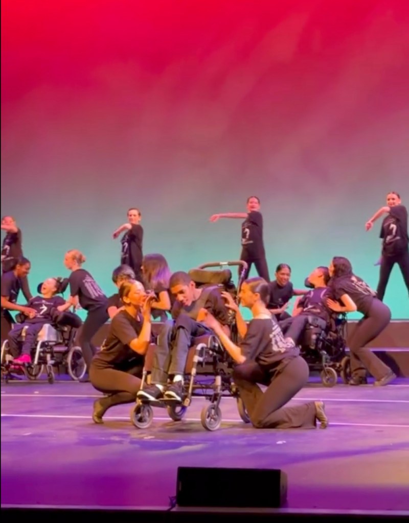 Dancers pushing Amari Thompson's wheelchair