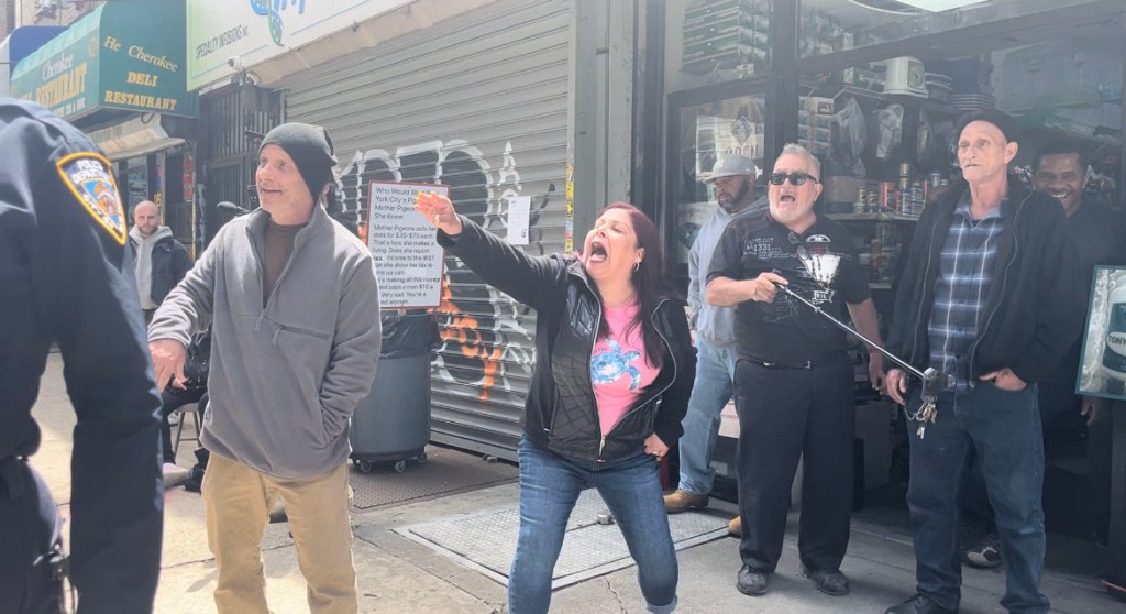 Broadway Pigeon & Pet Supplies employees, including Joey Scott (left), spar with activists at a Sunday protest. 
