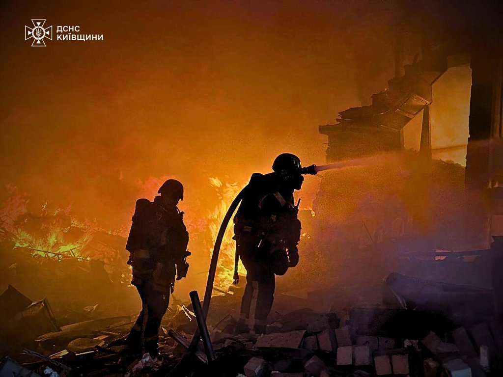 Ukrainian firefighters working to extinguish fires on residential homes following a Russian airstrike in the Kyiv region, 25 May 2025.