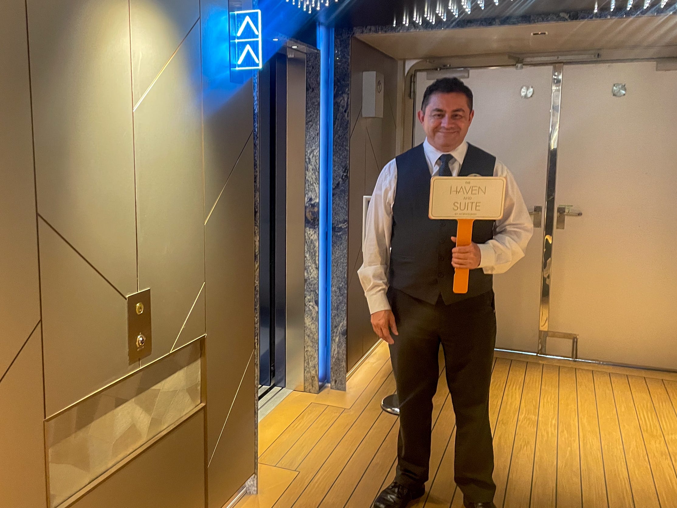 person holding a Haven Suite sign on Norwegian Aqua