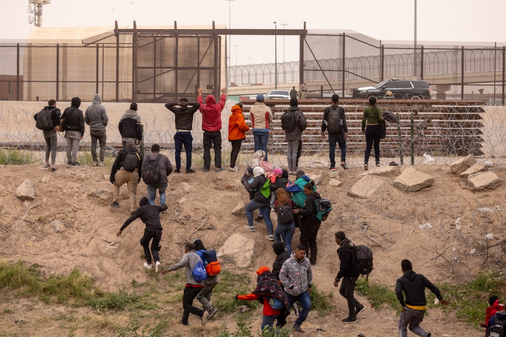 Texas National Guard troops pushing back migrants who have crossed into the U.S. from Mexico at El Paso, Texas on March 24, 2024