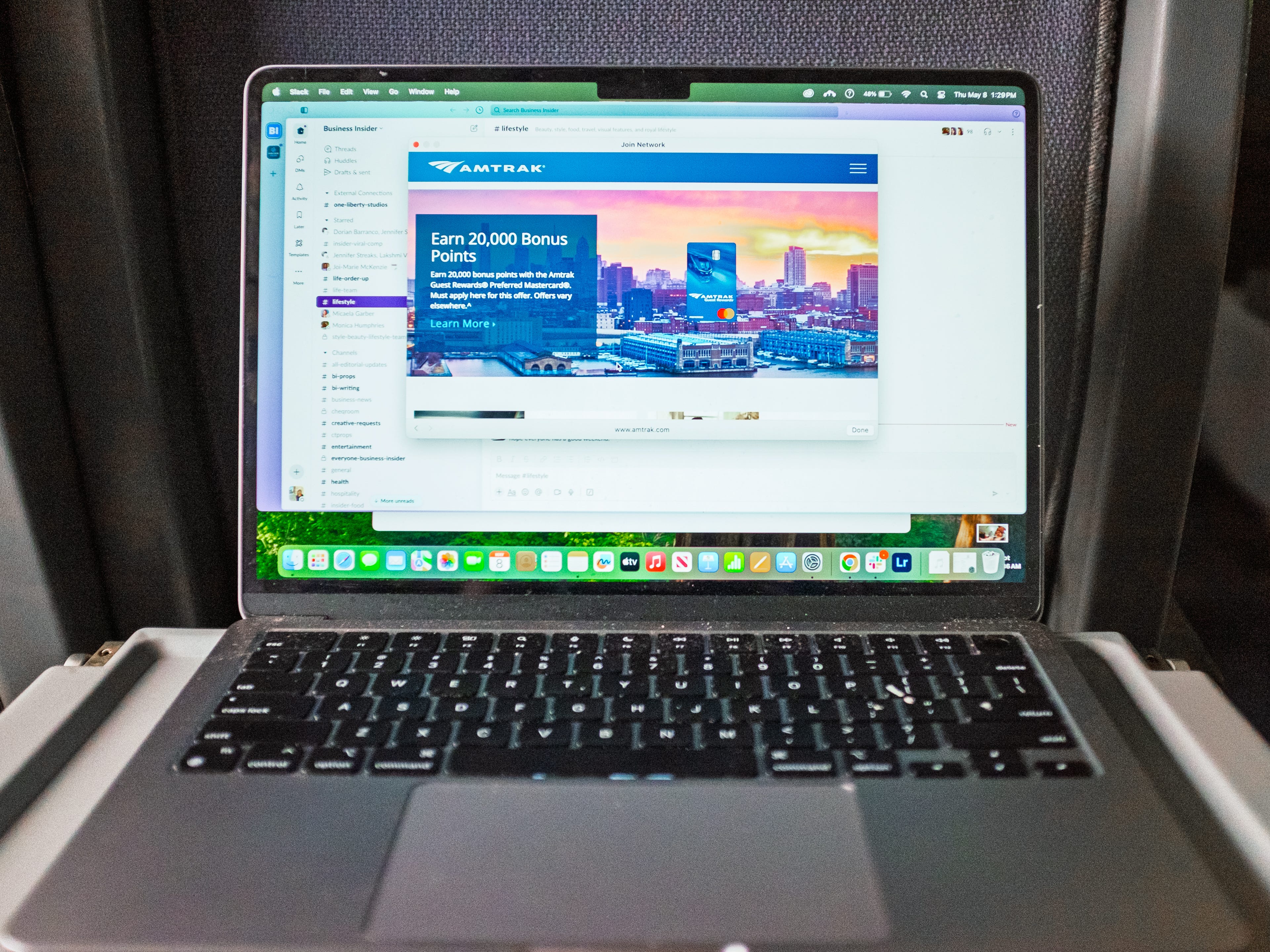 A laptop opened on a tray table on a train