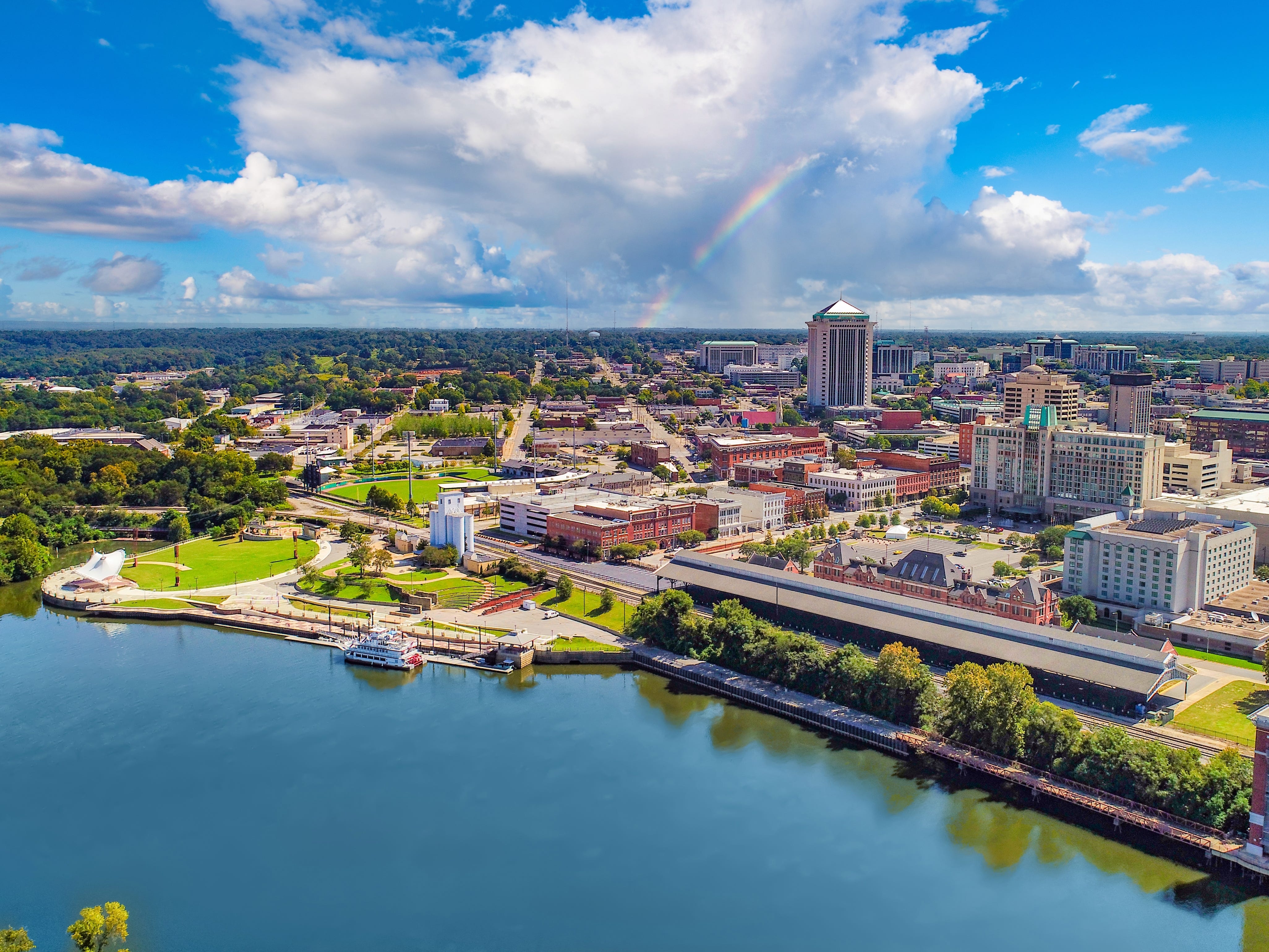 A city seen from the water with a rainbow overhead