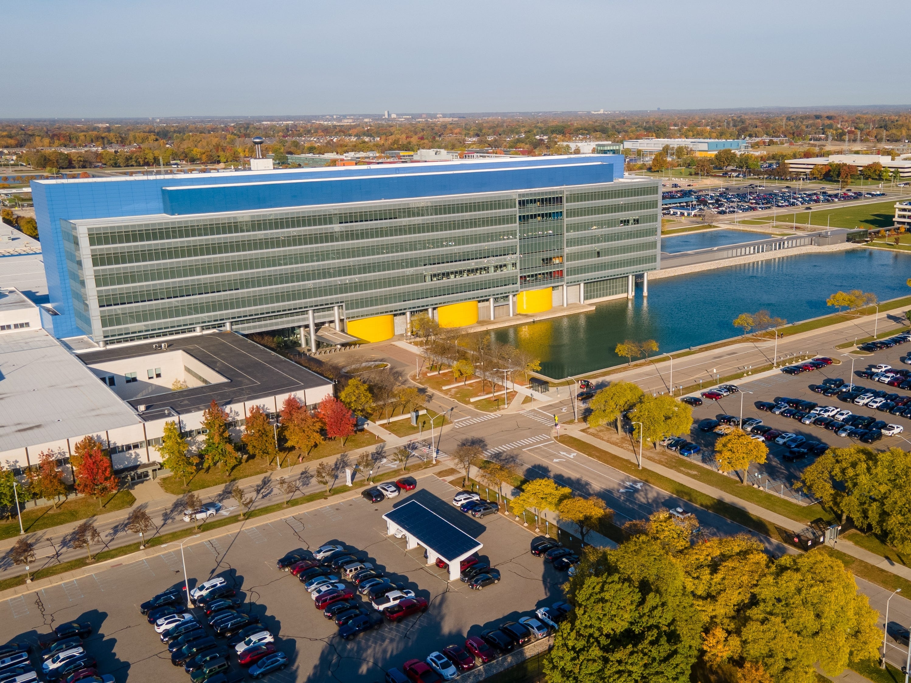 A long gray building with a blue structure behind it and mars in the parking lot