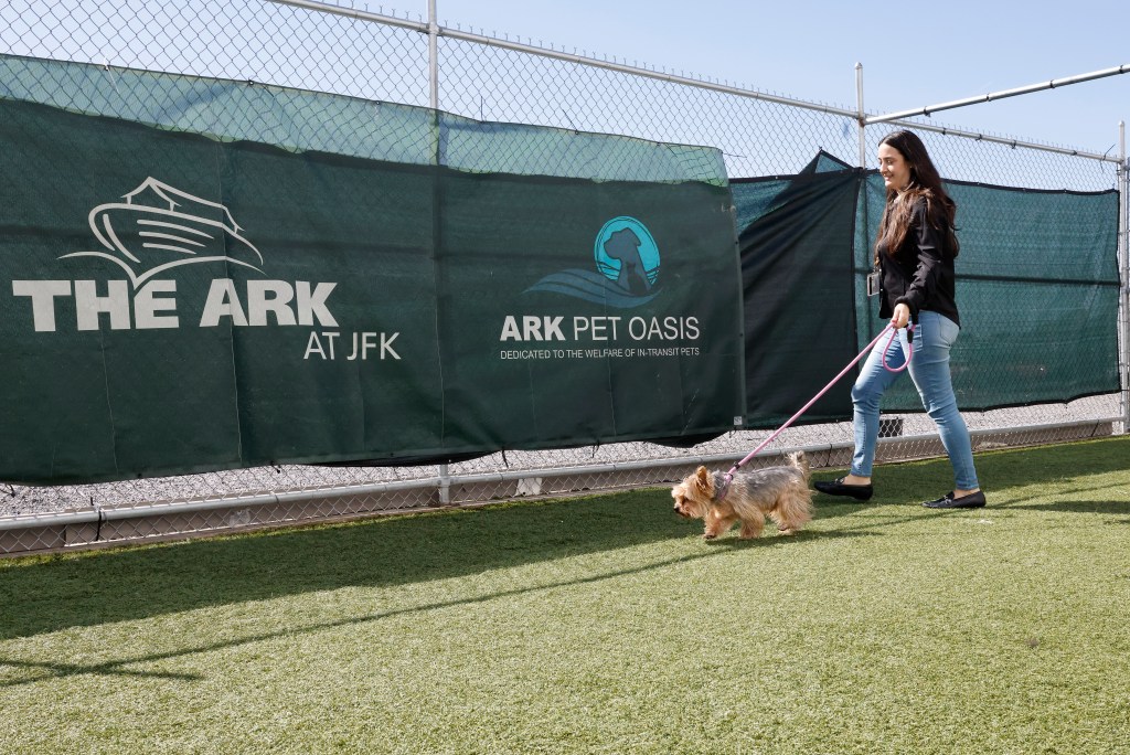 Kiera walking pup Luca in the outdoor relief area of The ARK Pet Oasis at JFK airport, a quarantine and veterinary service for travelling animals.
