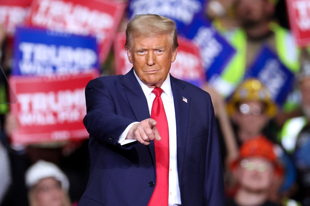 Former US President Donald Trump gesturing during a campaign rally at PPG Paints Arena in Pittsburgh, Pennsylvania on November 4, 2024.