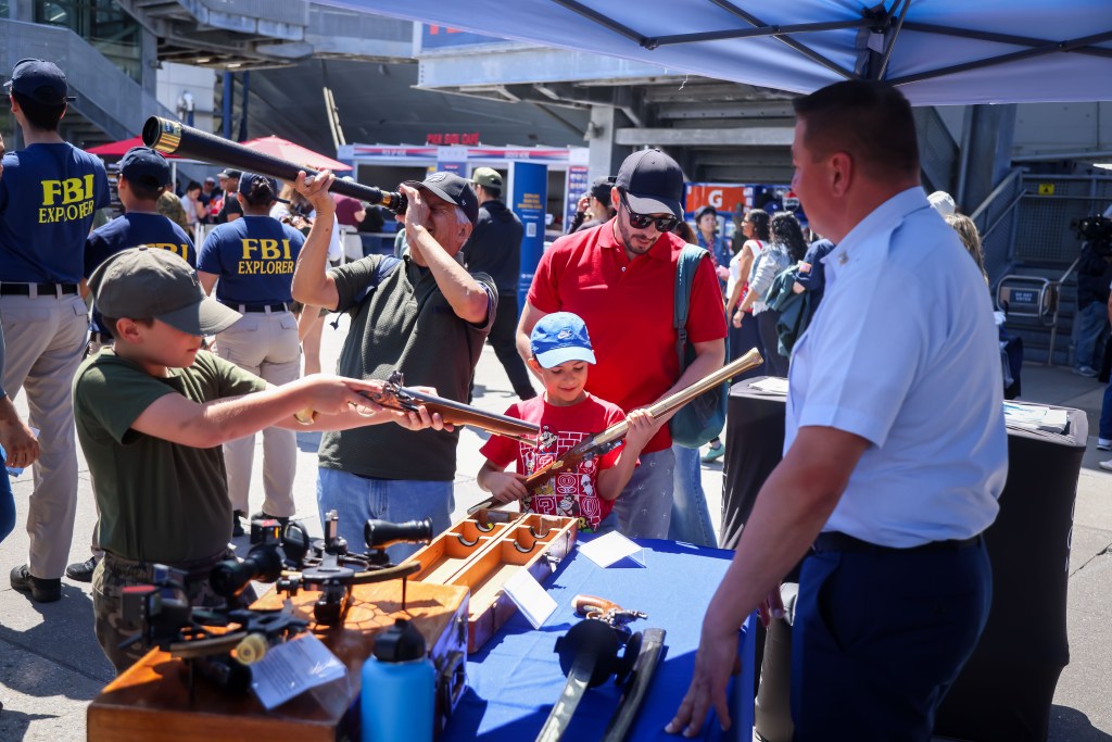 Visitors inspect antique rifles at a booth during the annual Memorial Day commemoration ceremony