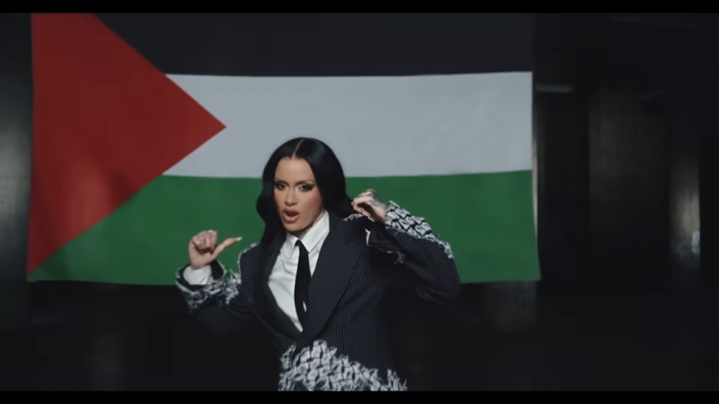 Musician Kehlani stands in front of a Palestinian flag in a music video.