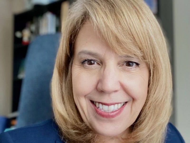 headshot of a woman in a navy blazer