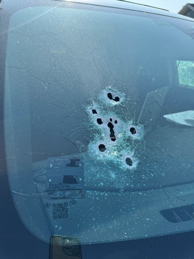 Bullet holes in the windshield of a police vehicle related to the incident of a man armed with garden shears being fatally shot.