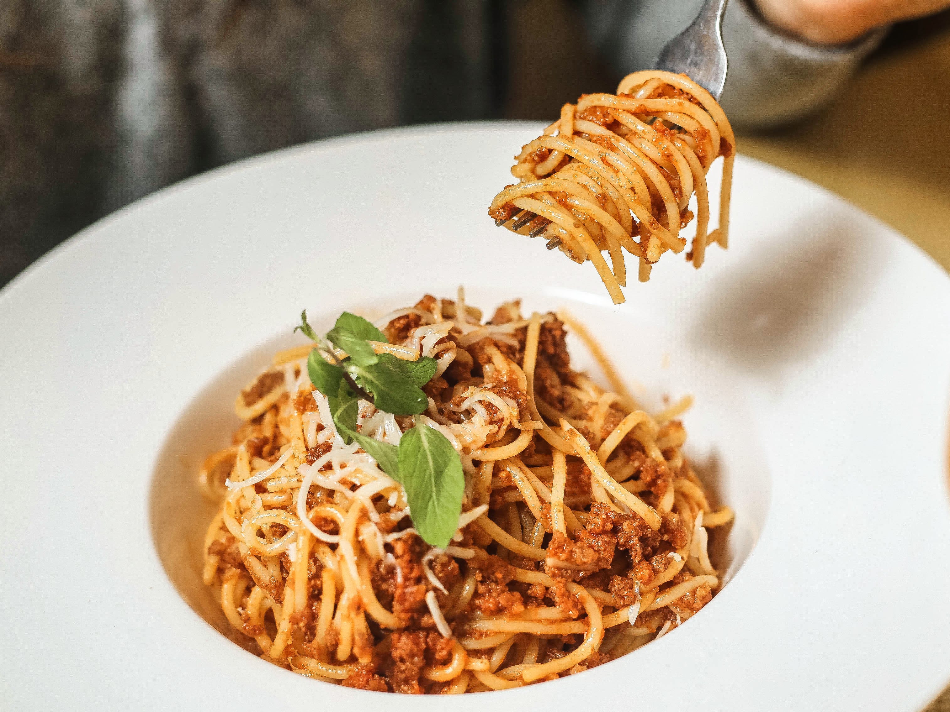 A bowl of spaghetti with a fork twirled in the pasta.