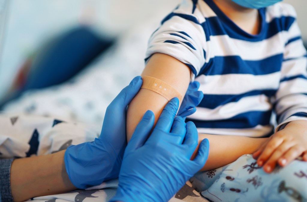 A child gets a bandage after receiving a COVID shot.