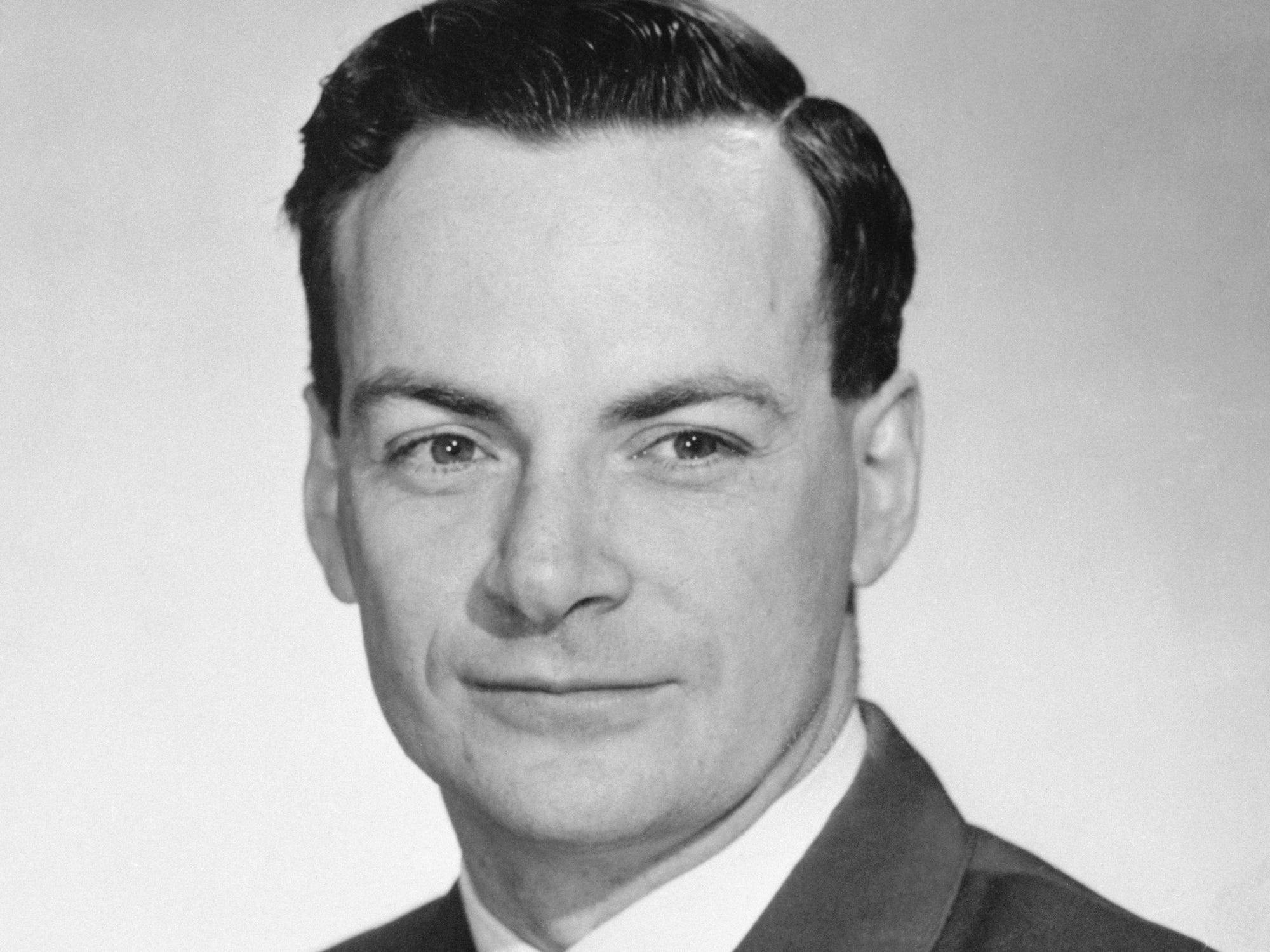 Nobel Prize winner Richard Feynman wears a suit against a light background in 1954