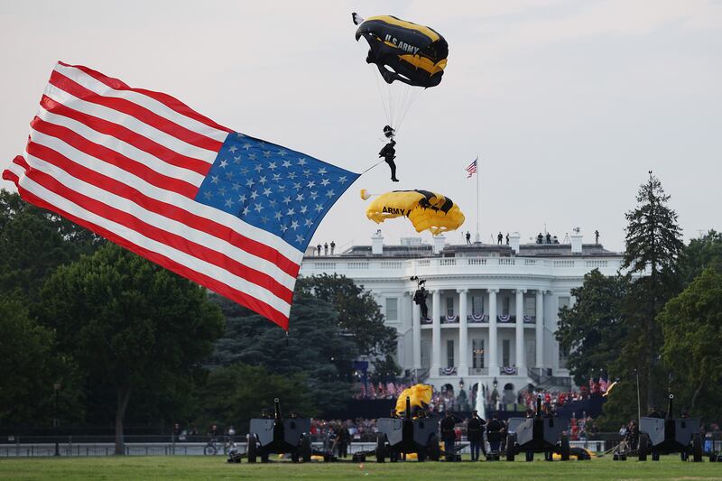 A member of the U.S. Army Golden Knights Parachute Team displays an American flag while landing on the Ellipse near the White House on July 4, 2020 in Washington.
