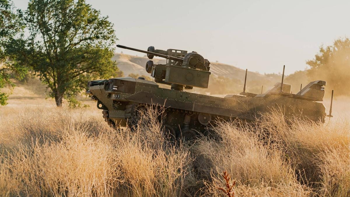 The Textron Ripsaw M3 drives through dry grass in an open field.