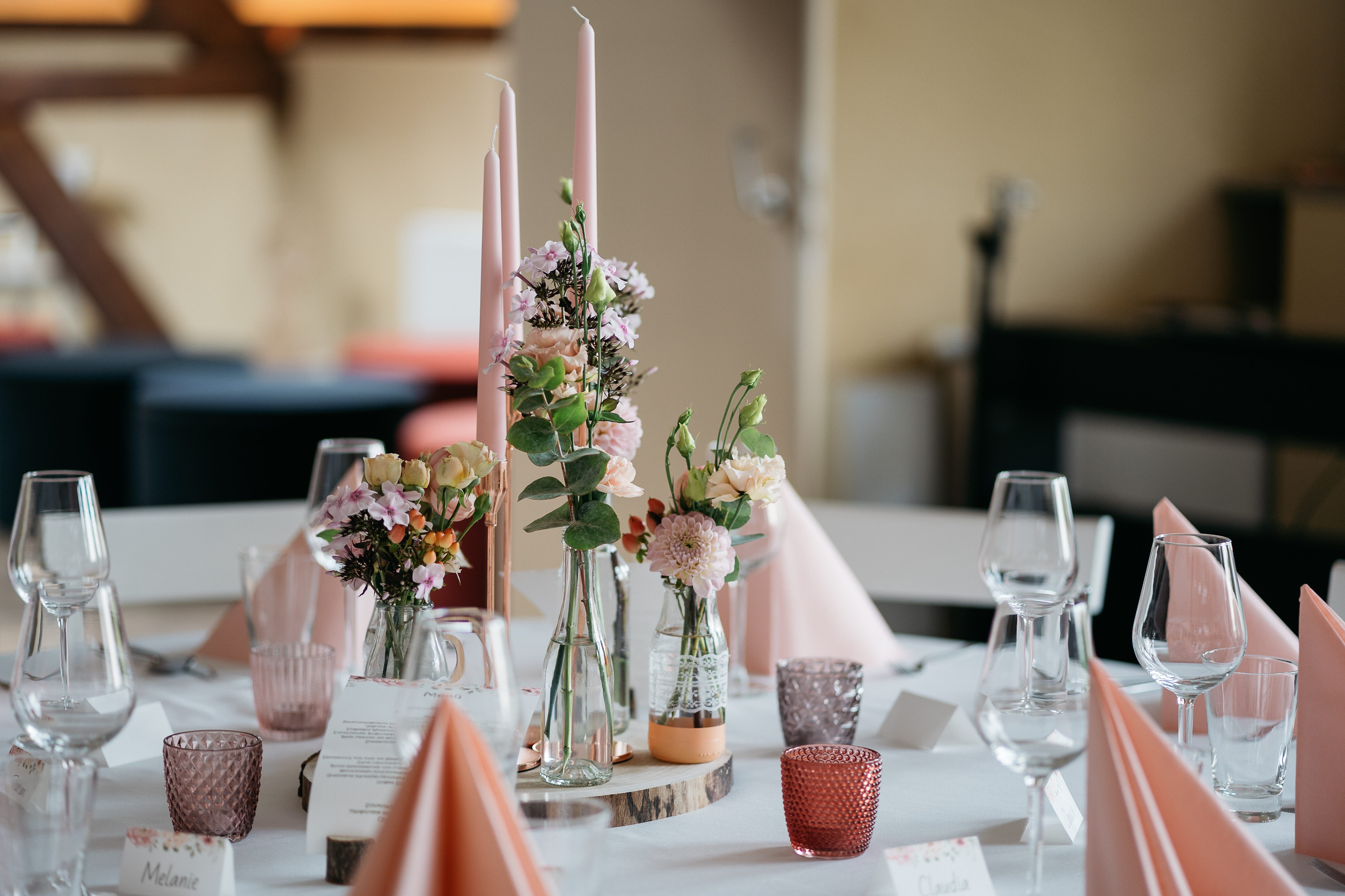 Wedding table with bud vases, pink candles, place cards