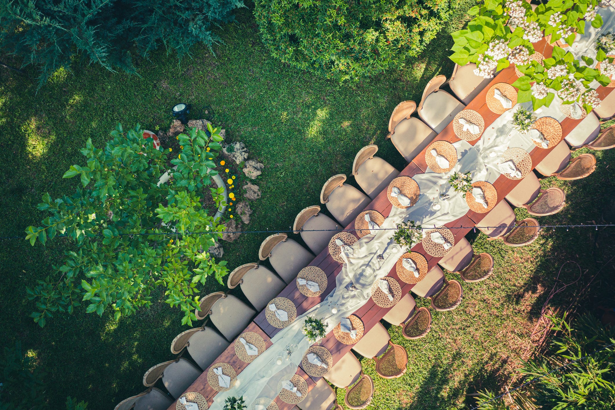 An aeriel view of a large wedding dinner table in backyard.