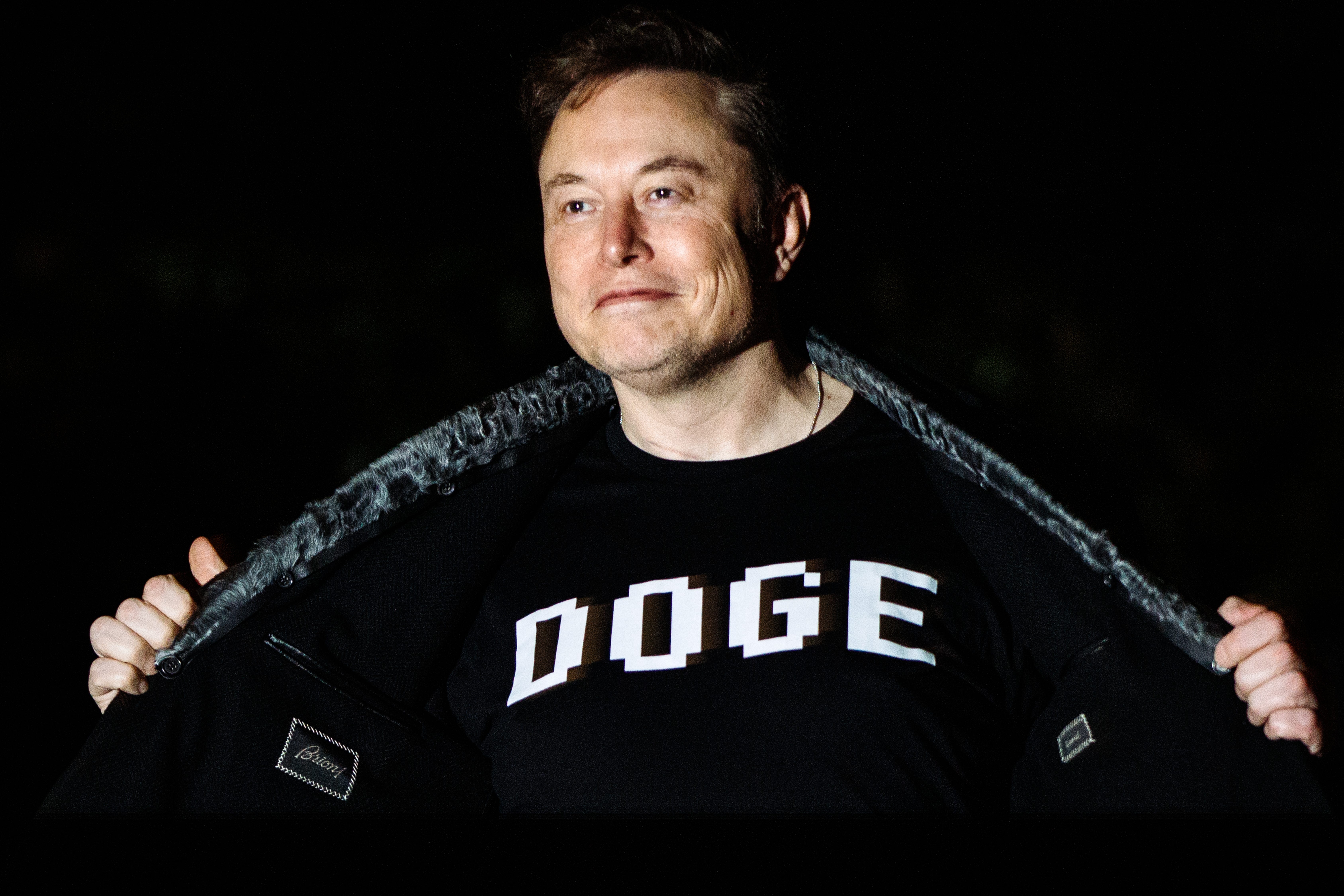 Elon Musk showing off his DOGE T-shirt at the White House.