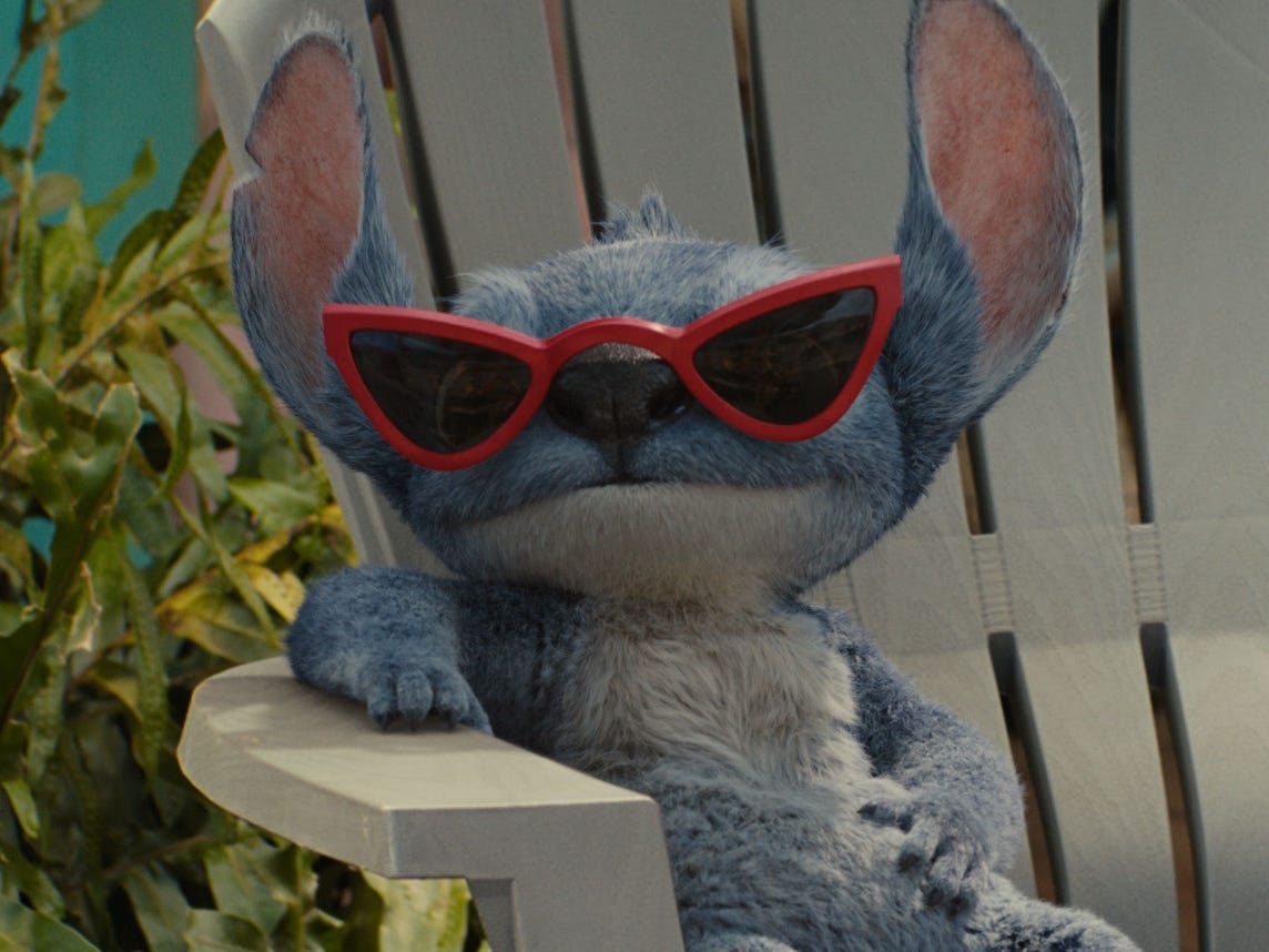 Stitch sitting in a chair wearing sunglasses