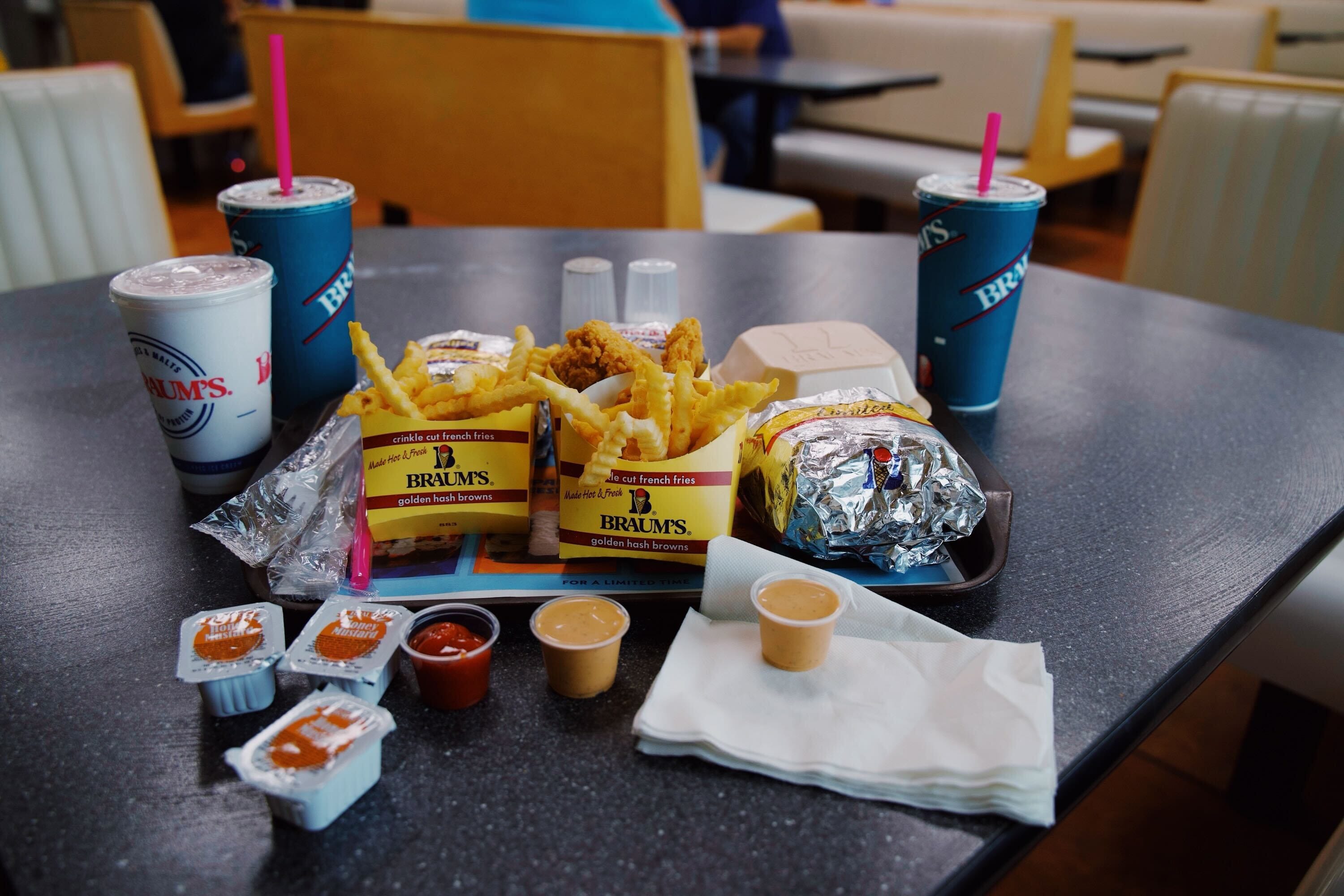 A Braum's tray filled with food like hamburgers, fries, tenders and a malt.