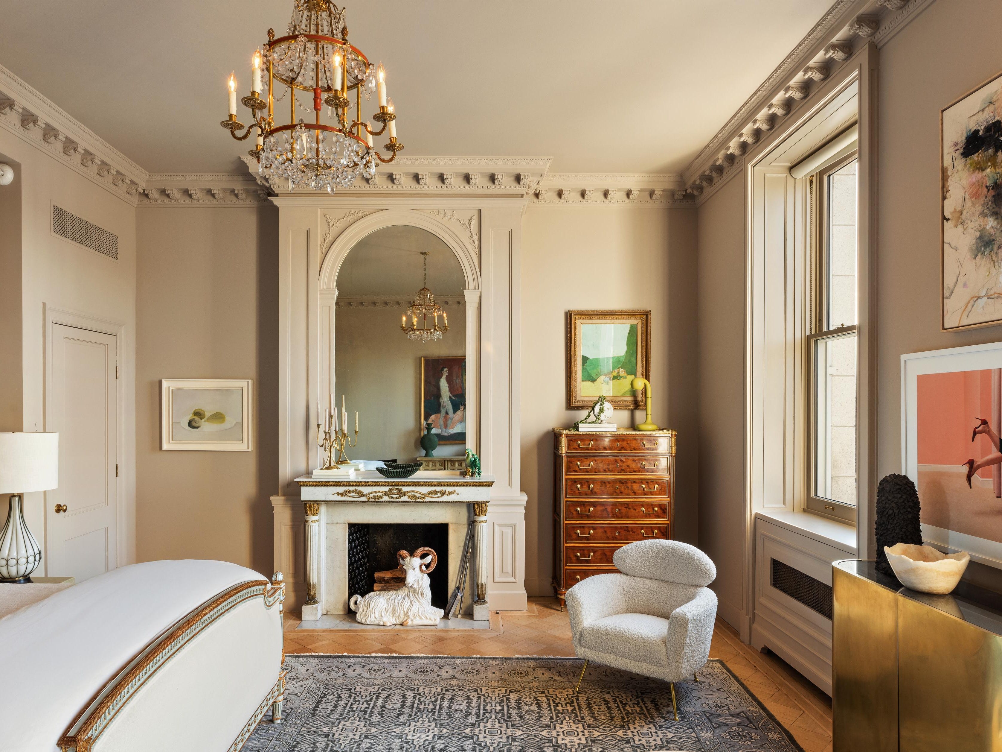 a bedroom with cream walls crown molding and a fireplace