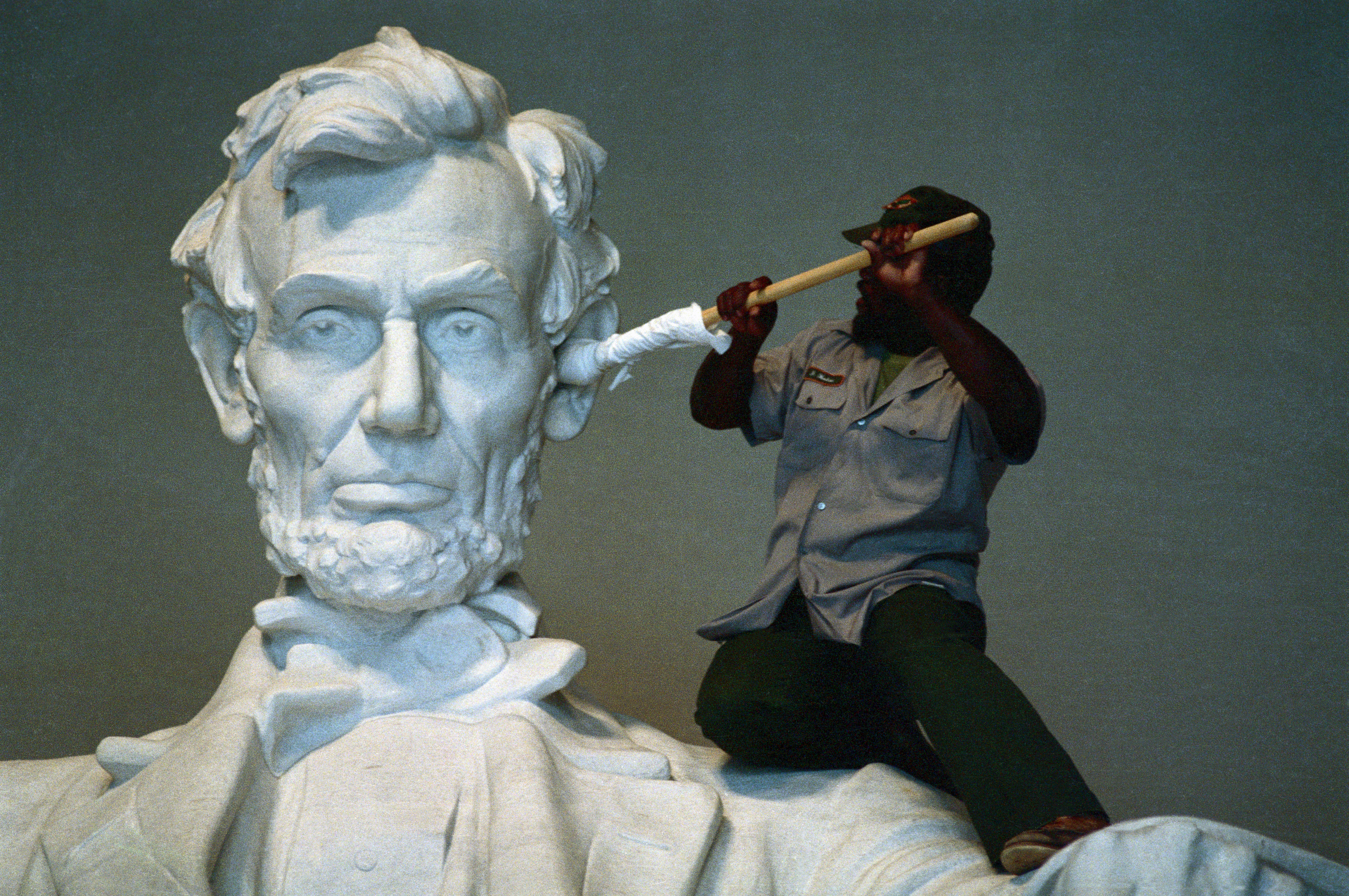 National Parks Service worker James Hudson uses a cloth-wrapped pole to clean the ear of the statue at the Lincoln Memorial in 1987.