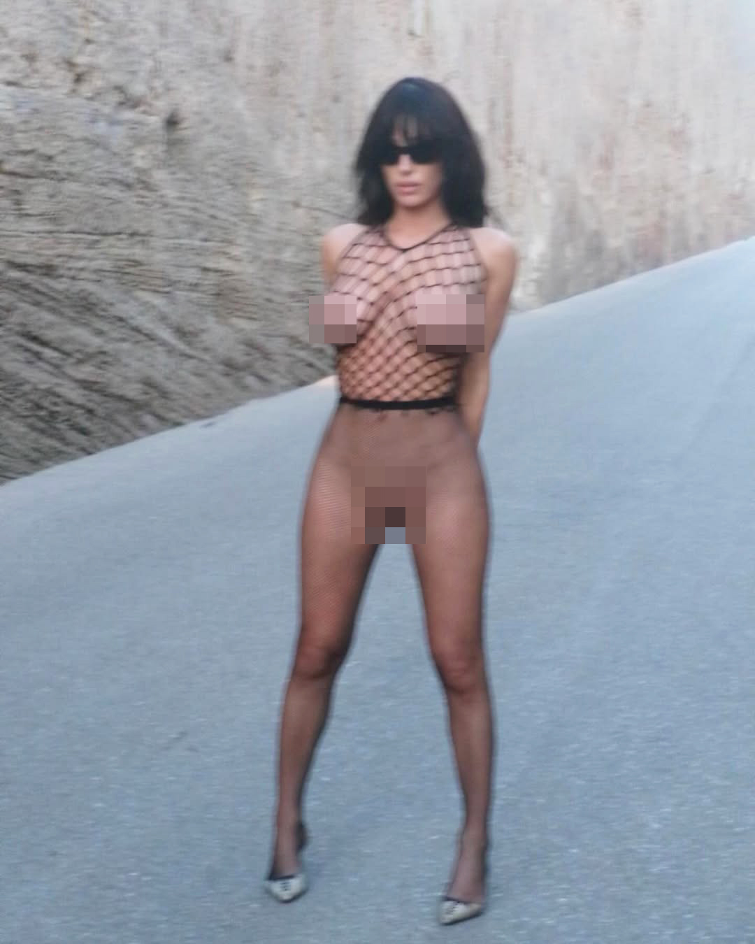 Bianca Censori wears a fishnet top and sheer tights. 