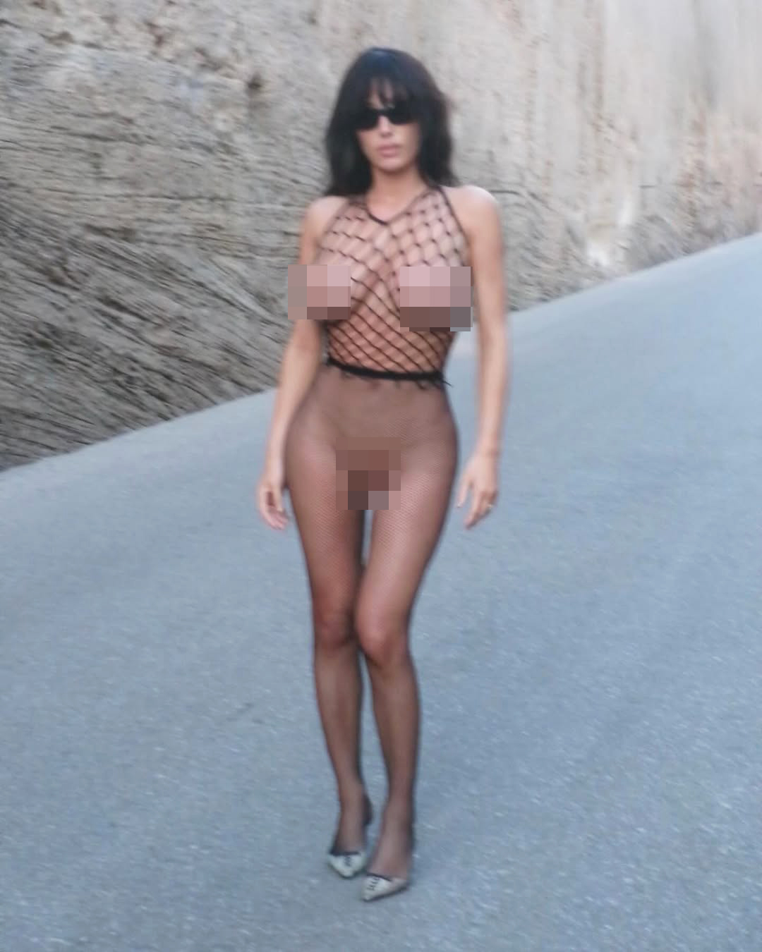 Bianca Censori in see through clothing on a road. 