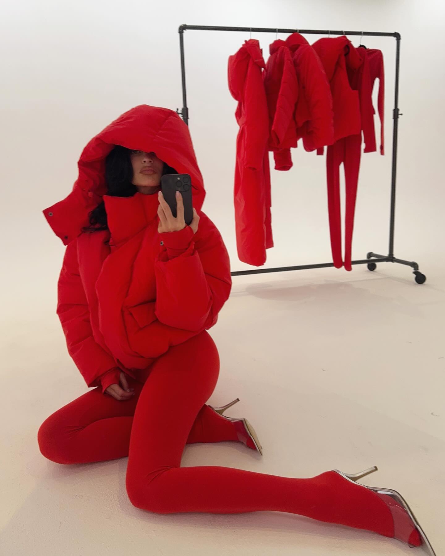 Kylie Jenner in a red puffer coat and leggings. 