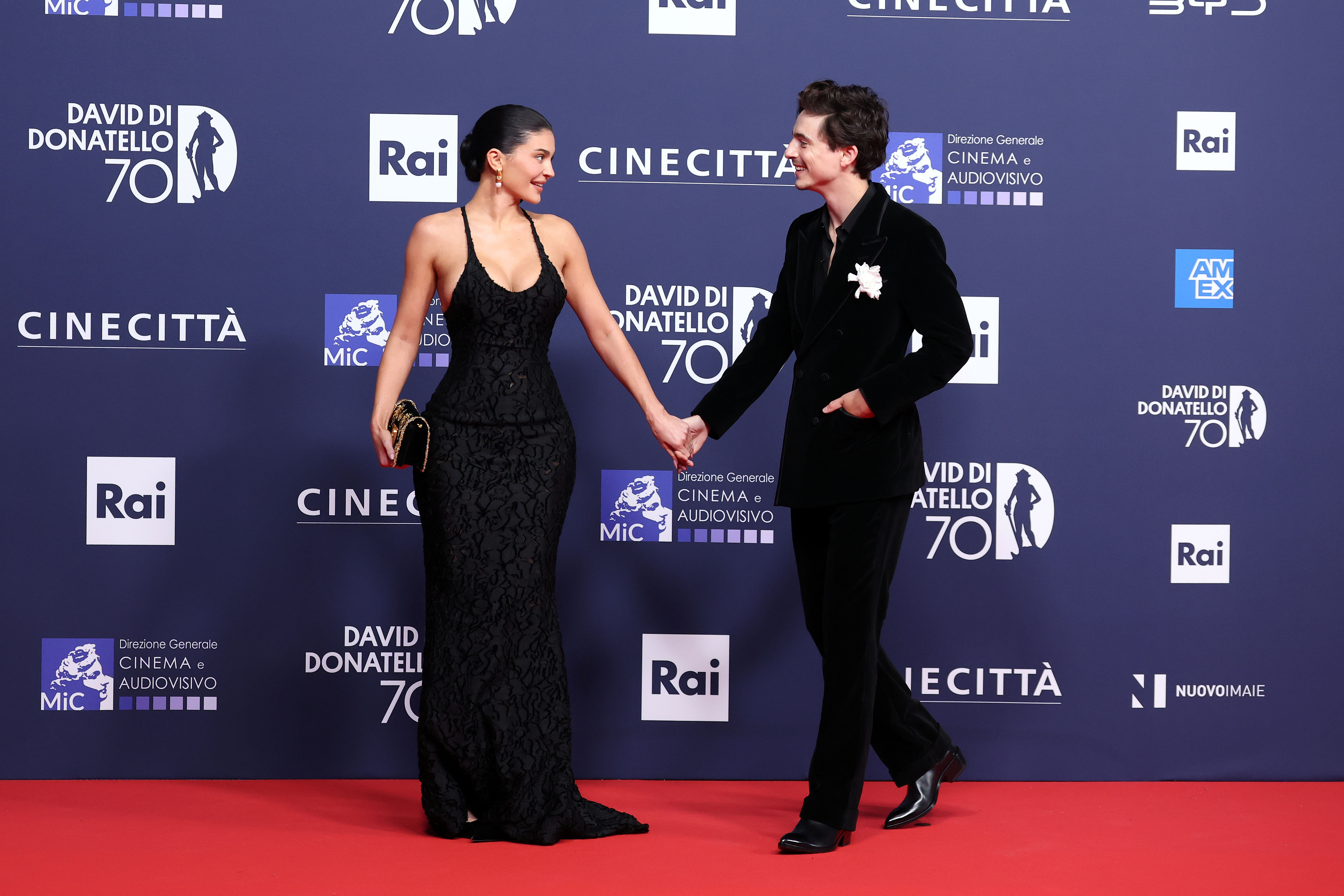 Kylie Jenner and Timothee Chalamet wear black on a red carpet. 