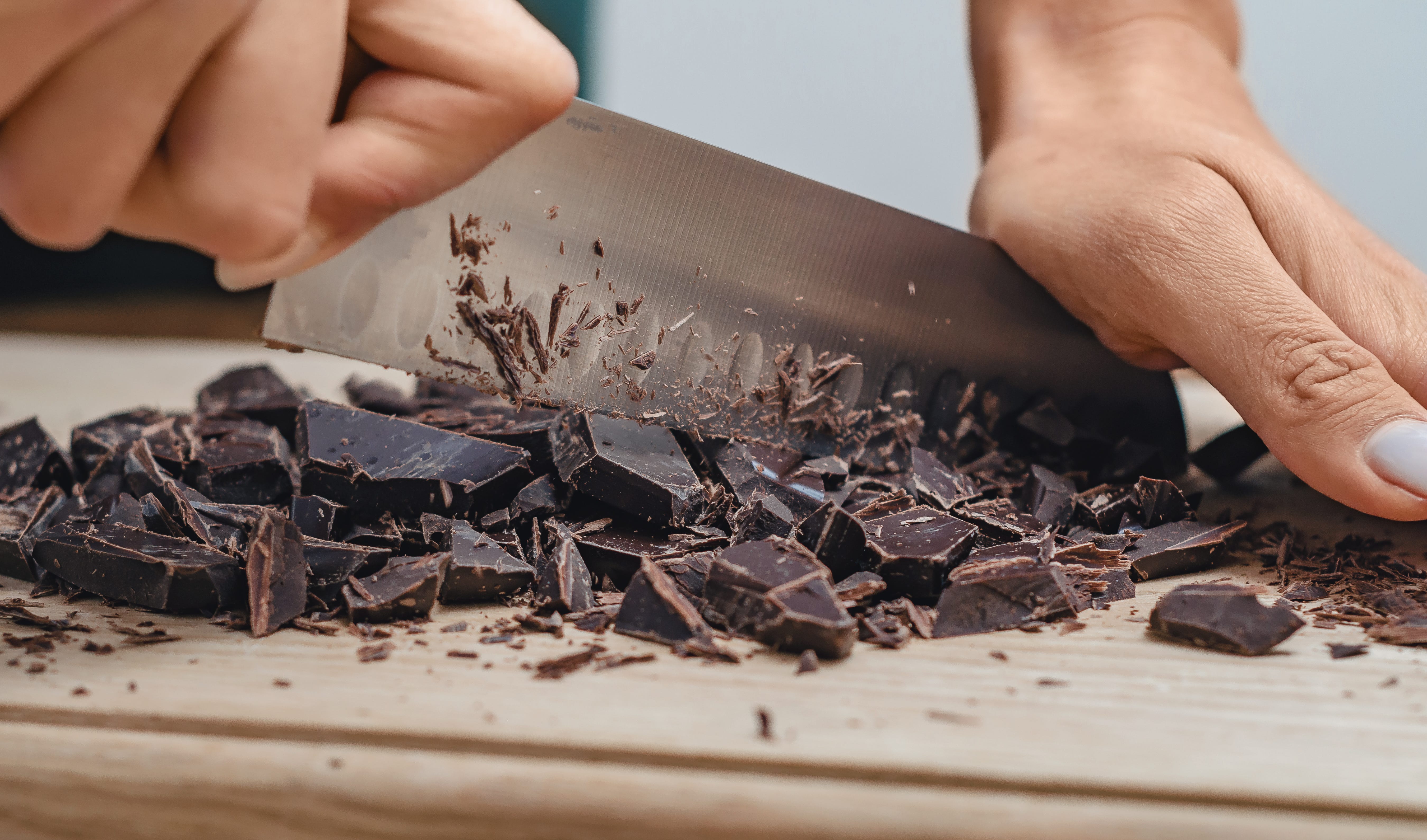 Hands chopping chocolate with knife