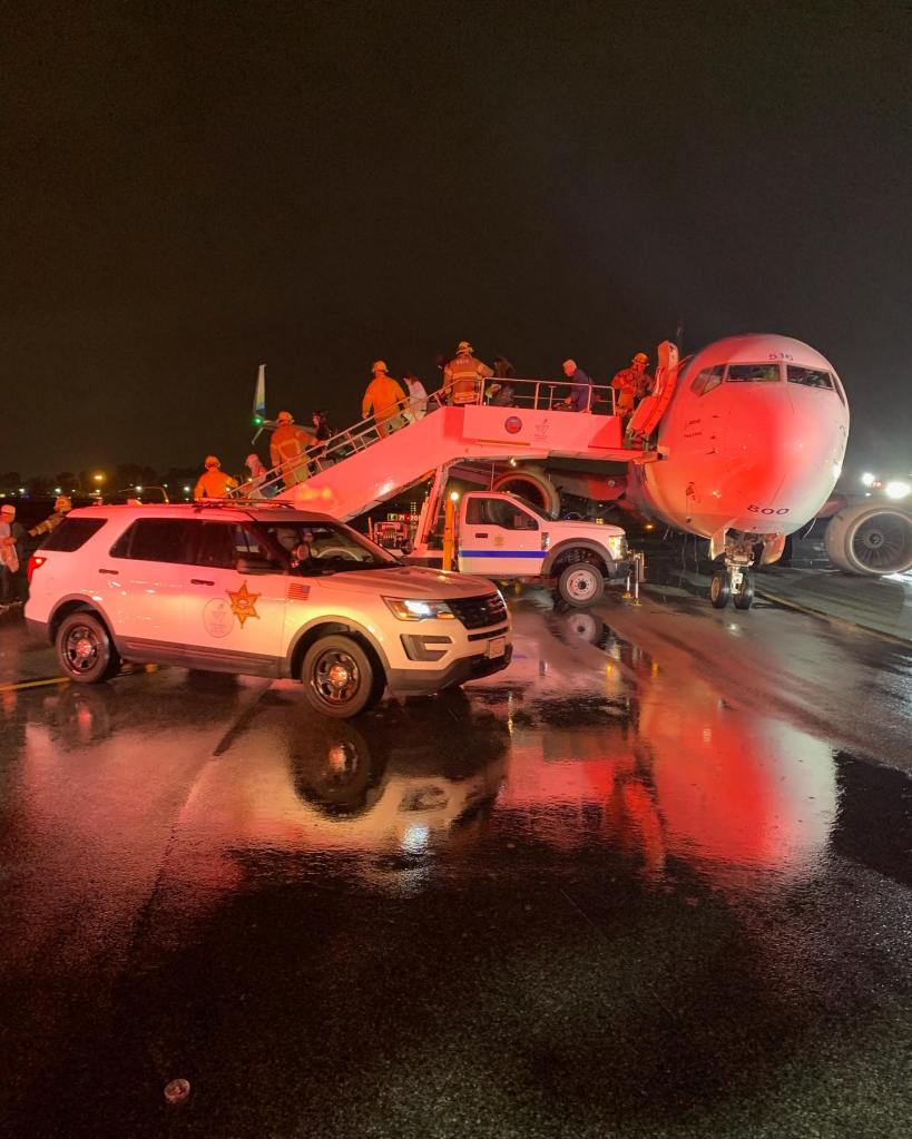 First responders help passengers disembark the Alaska Airlines 737 after the rough landing at John Wayne Airport on Aug. 20, 2023.