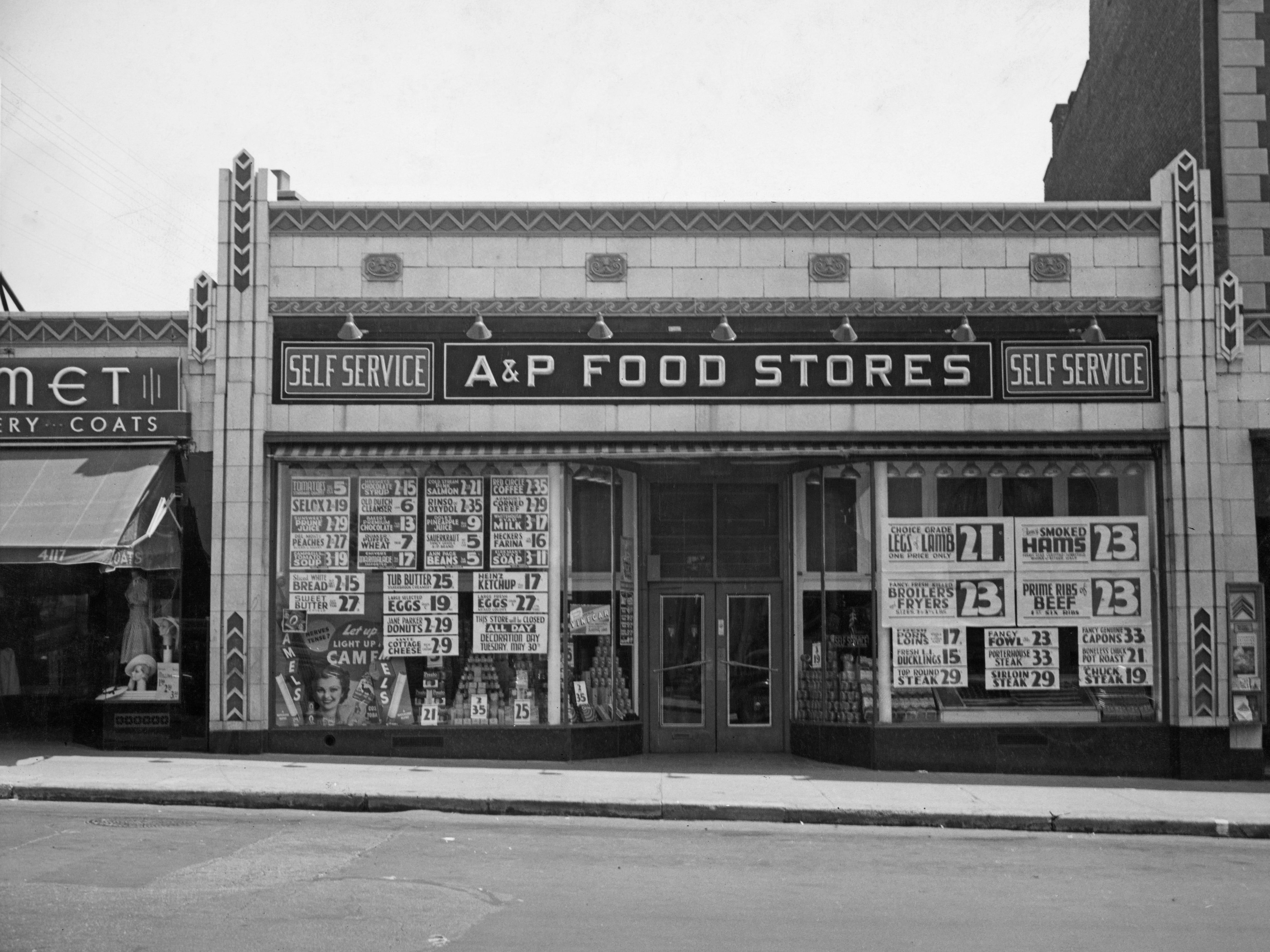 An A&P store with signs reading self-service and ads on the windows