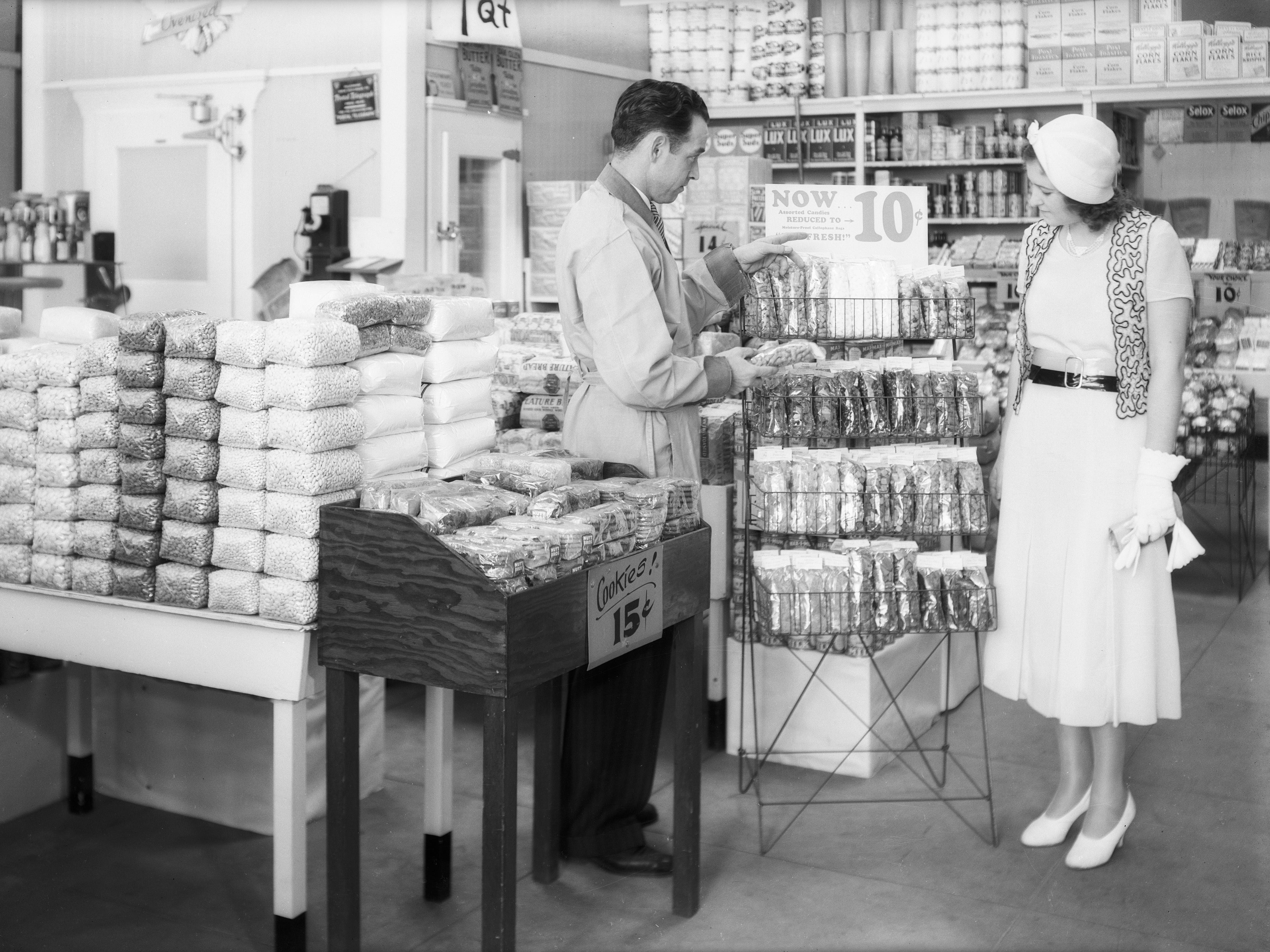 A clerk shows a woman products in a grocery store