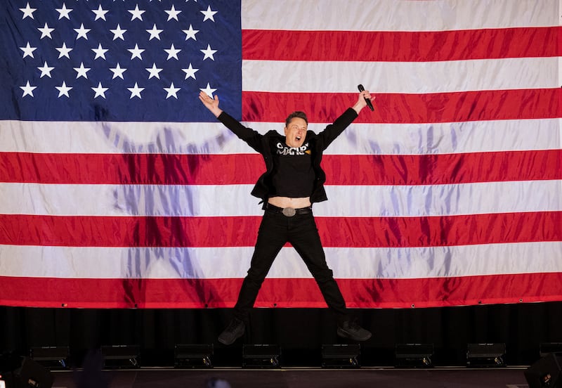 Elon Musk jumps on stage as he arrives to speak at a town hall event hosted by America PAC in support of Donald Trump.