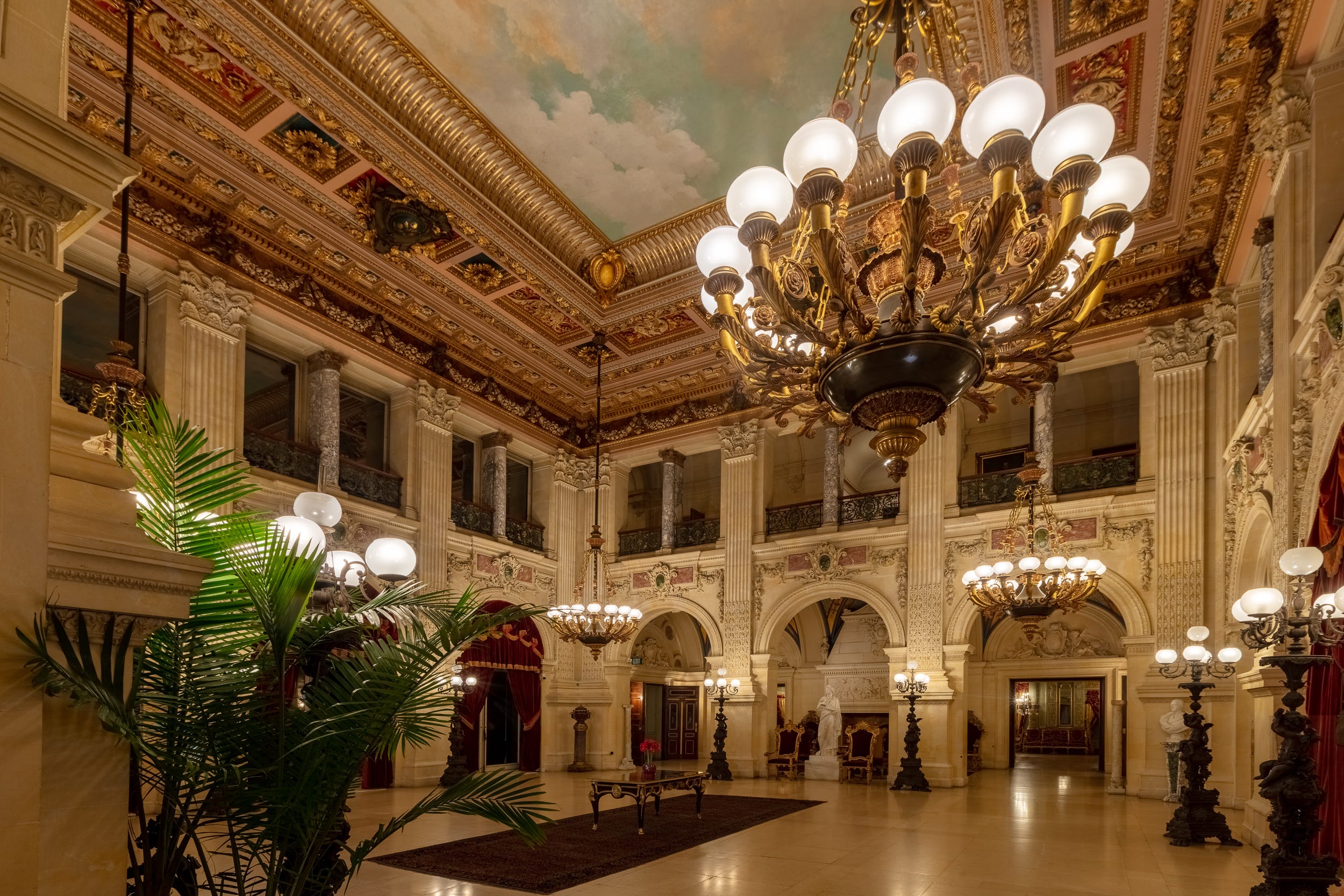 The Great Hall at The Breakers. An ornate Gilded Age room with columns and large chandeliers.
