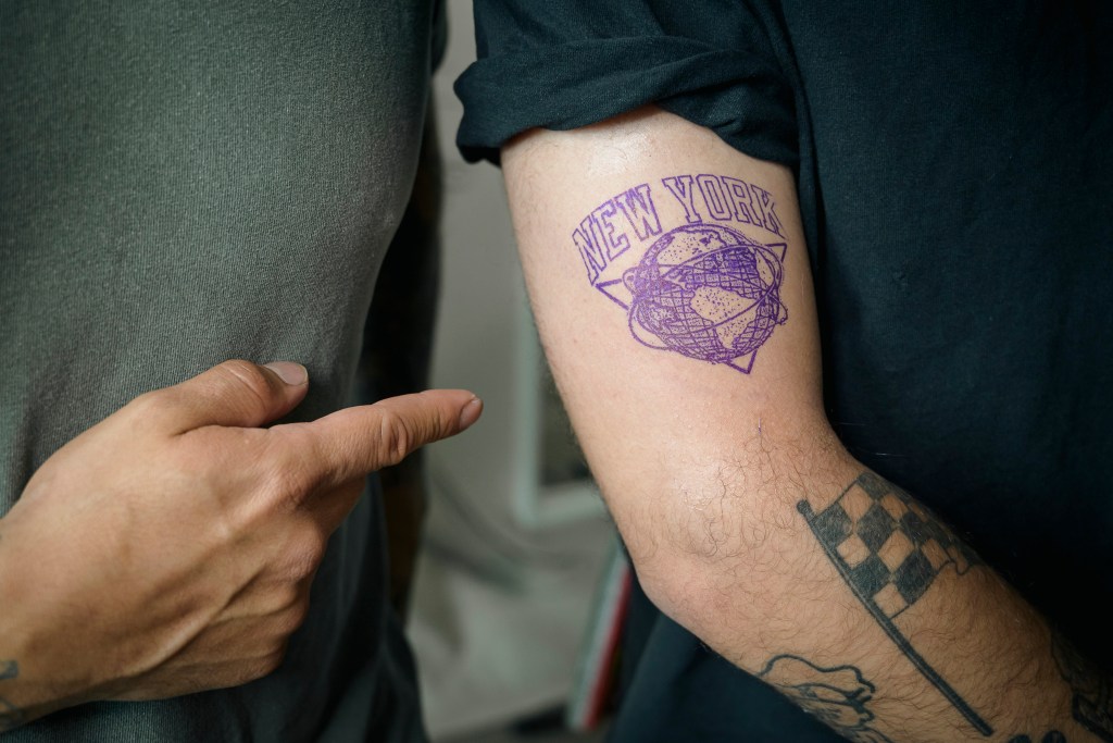 Nikhil Dhanani, a Queens resident, is getting a tattoo with the Knicks basketball logo by Steven Avalos, .
a Brooklyn tattoo artist, in his studio.