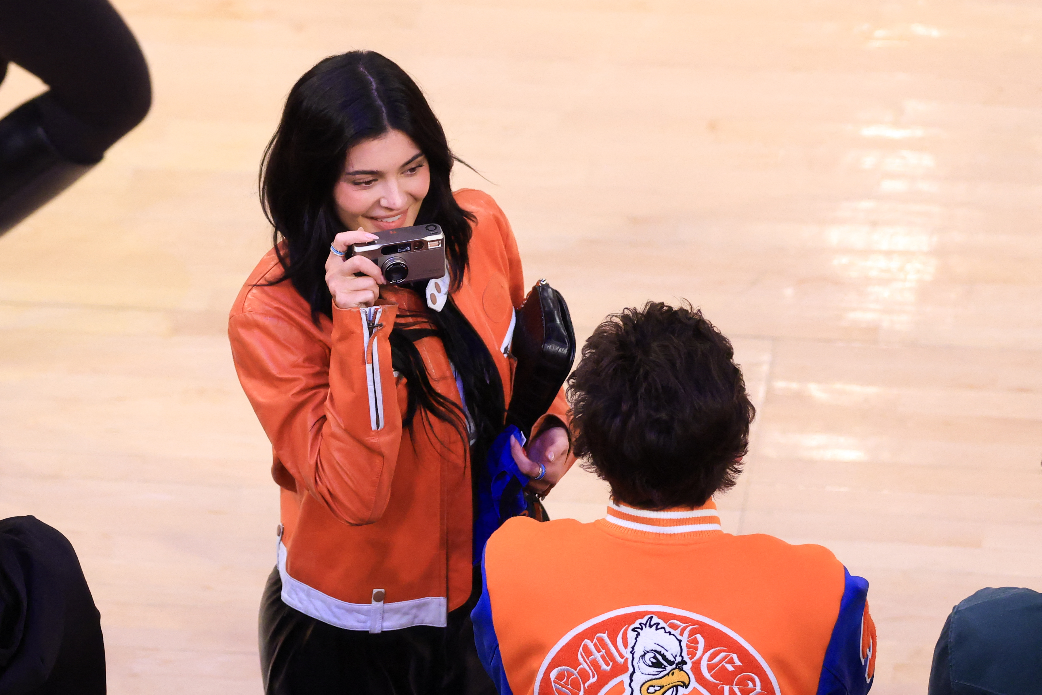 Kylie Jenner takes a photo of Timothee Chalamet at a basketball game. 