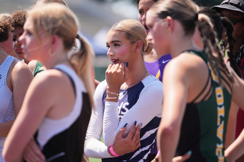 AB Hernandez joins female competitors before the girl's high jump event.