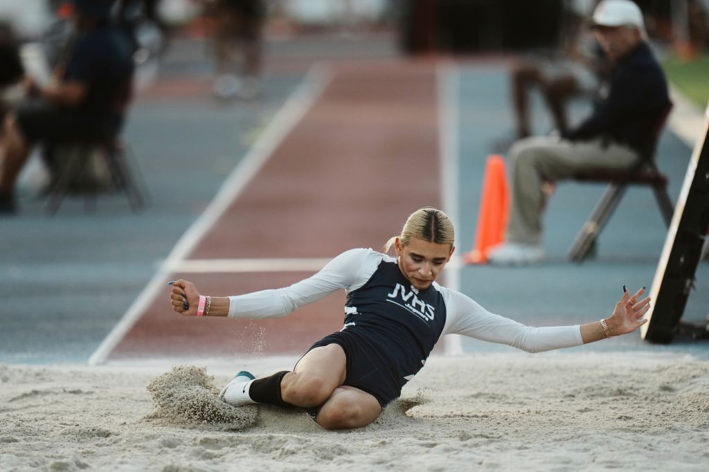 AB Hernandez lands in the sand pit after completing a jump during the triple jump.