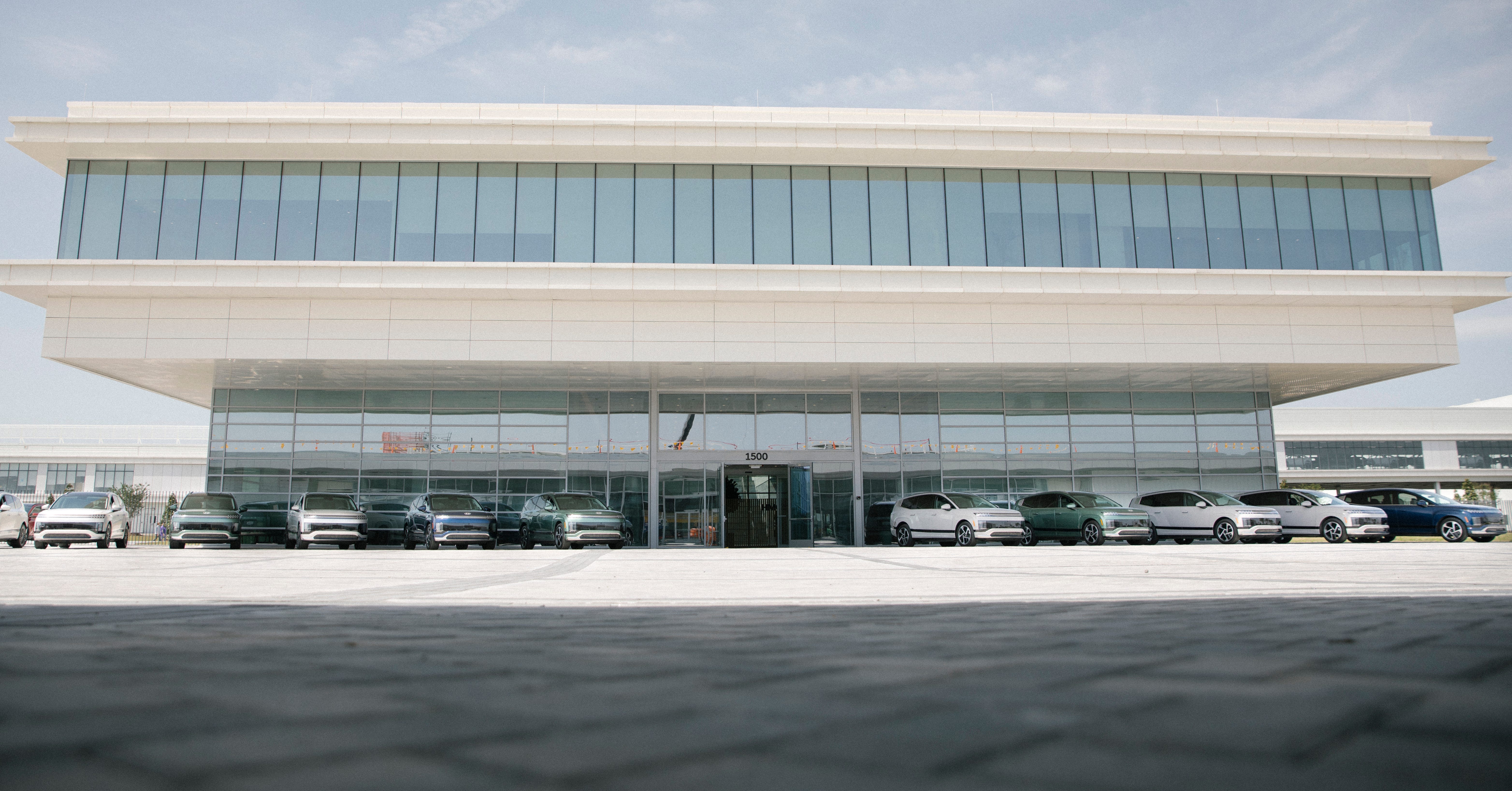 A row of Hyundai Ioniq 9 EV SUVs is parked in front of the lobby of the Hyundai Motor Group Metaplant America in Georgia