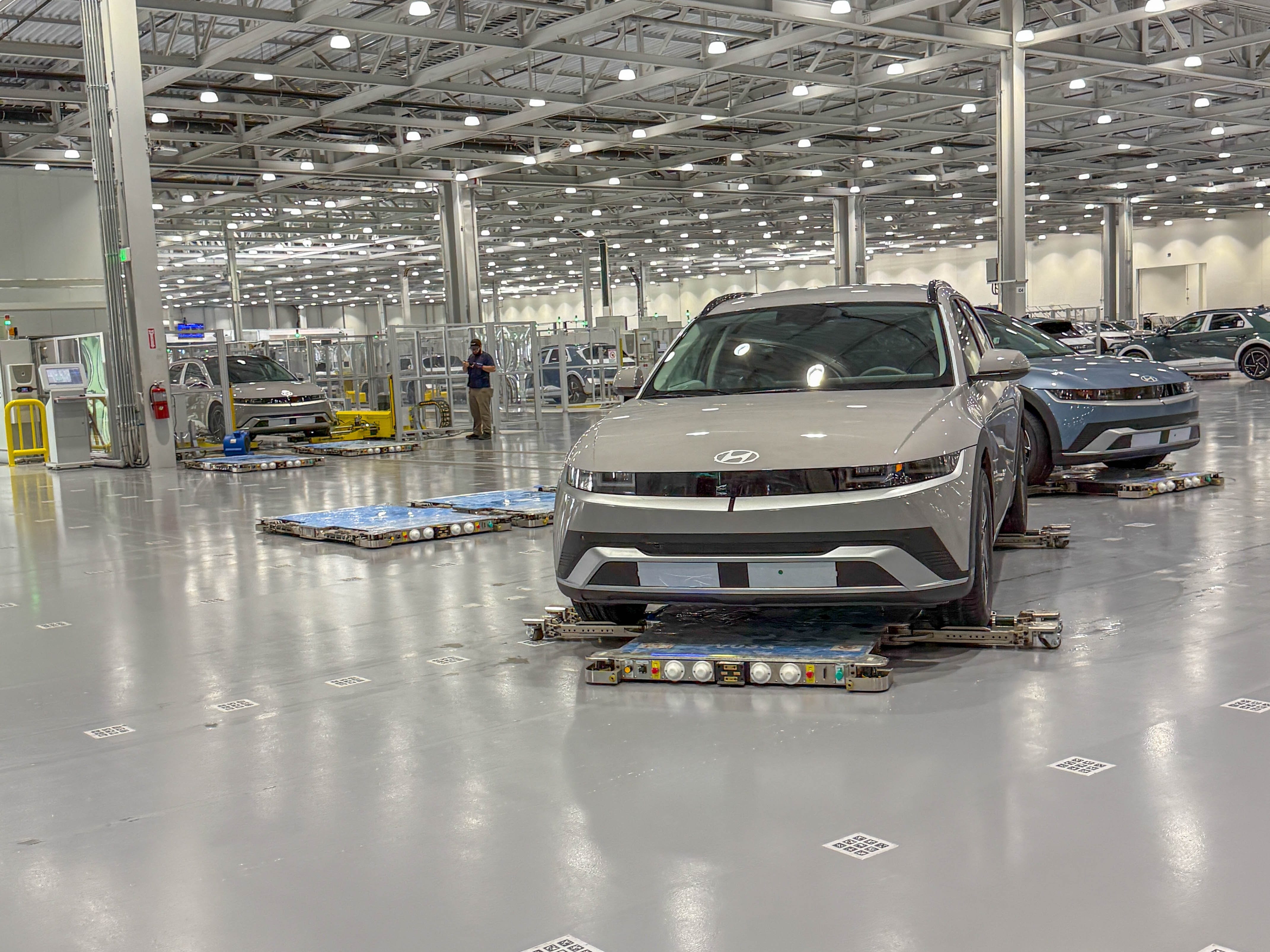 Hyundai Ioniq 5 EVs on autonomous transport robots leaving the soak testing in the Hyundai Motor Group Metaplant America in Georgia.