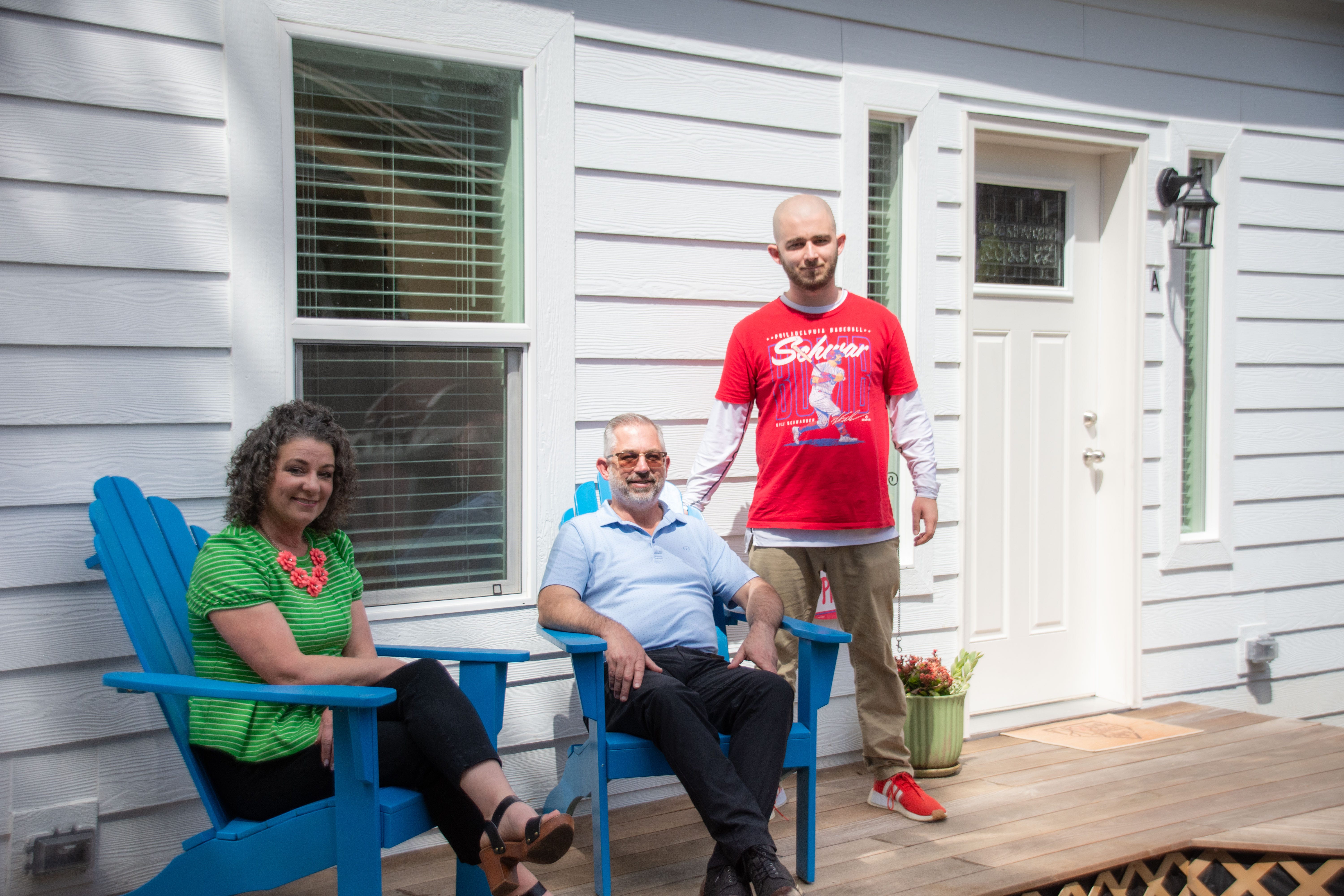 Todd Kuchta (center) and his wife and son are standing outside their ADU.