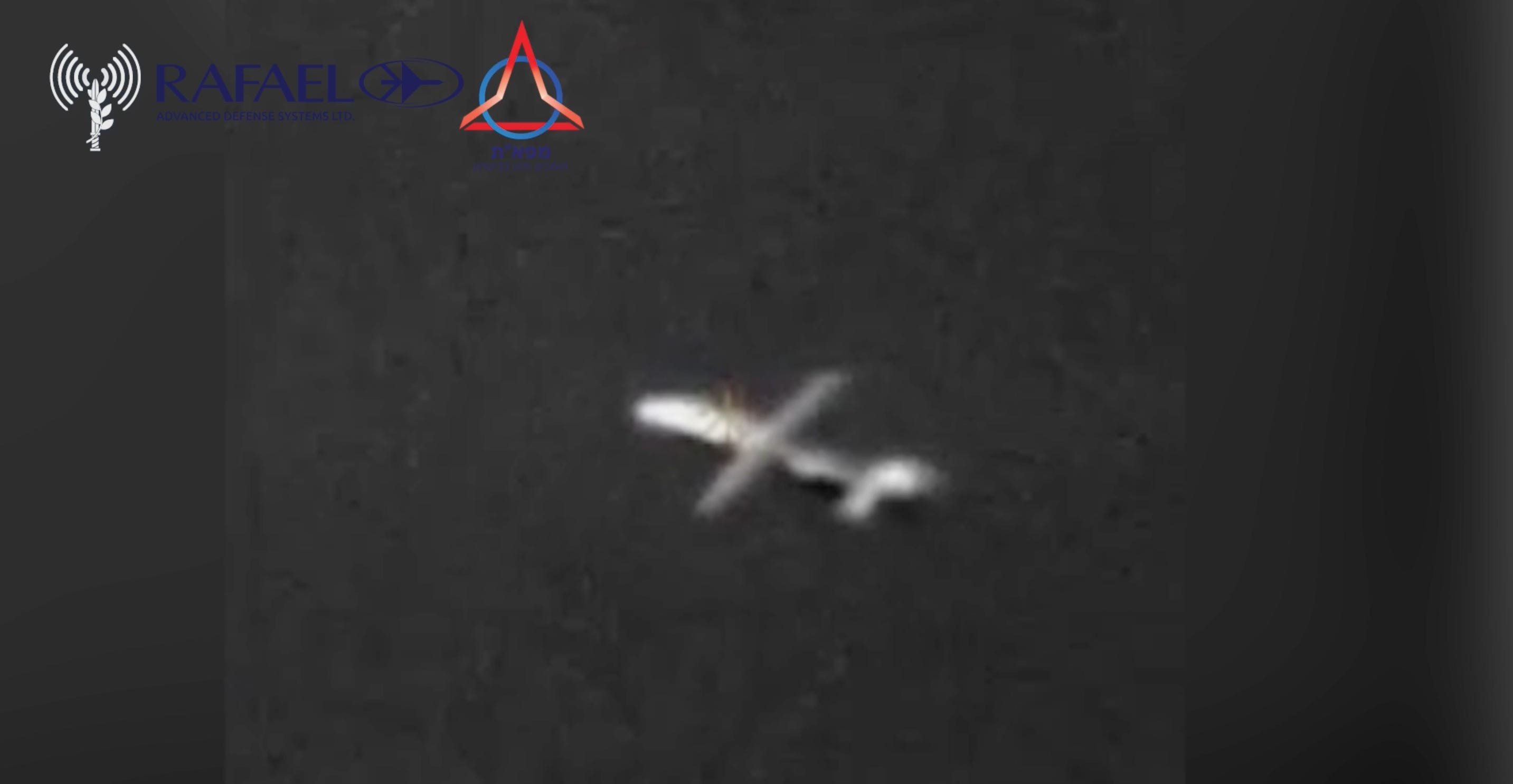 A video showing a white uncrewed vehicle flying with a small crosshair on it. Superimposed text at the top-left credits the video to the Israeli Ministry of Defense and Rafael Advanced Defense Systems.