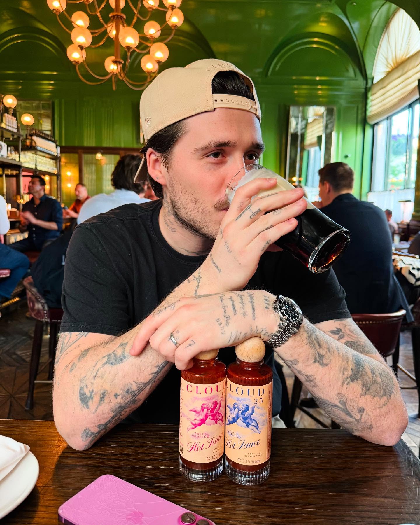 Hands off his hot sauce! Brooklyn Beckham tips back a beer.