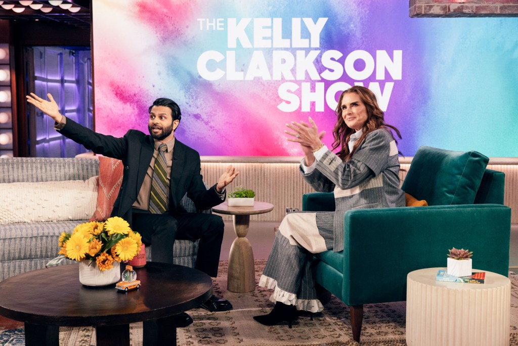 Brooke Shields in a grey and cream striped jacket and skirt, Asif Ali in a dark suit, brown shirt and brown striped tie.
