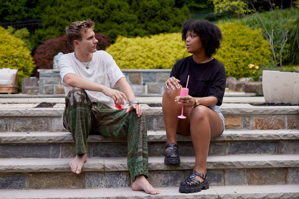 Charlie Zakkous and Riley Burruss sitting on outside steps talking on Bravo's 