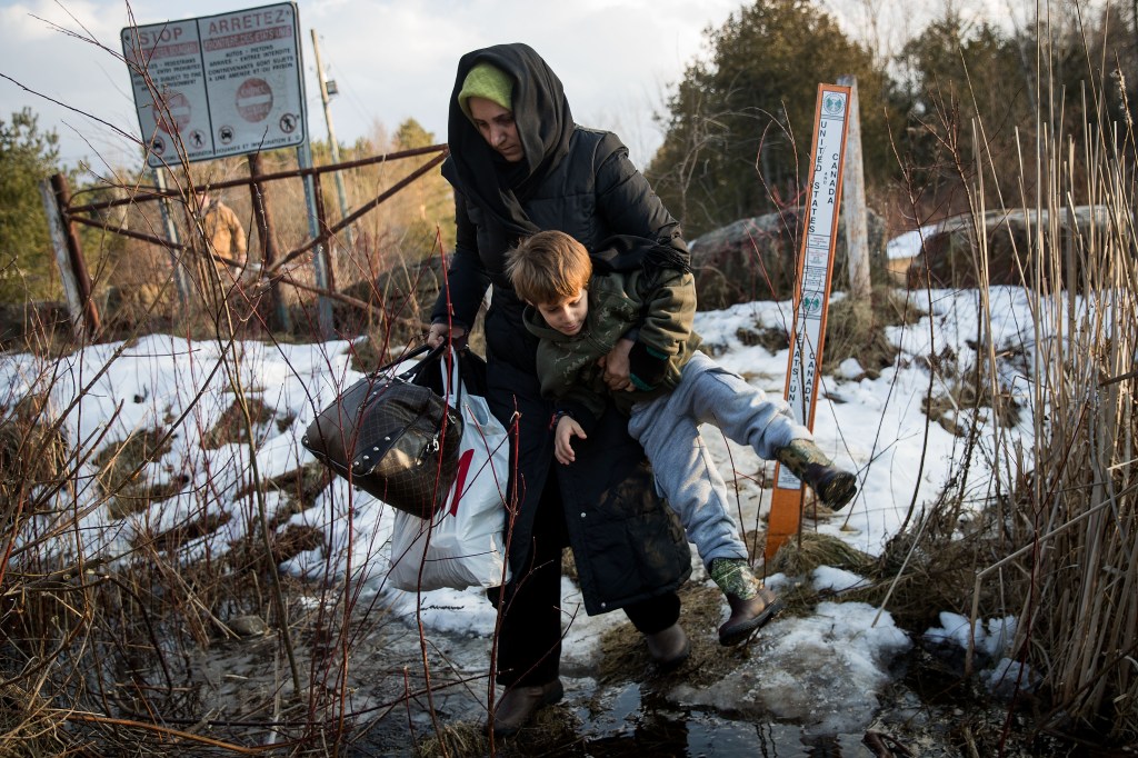 A mother and son from Turkey crossing a creek at the U.S.-Canada border in Hemmingford, Quebec seeking asylum, February 23, 2017.